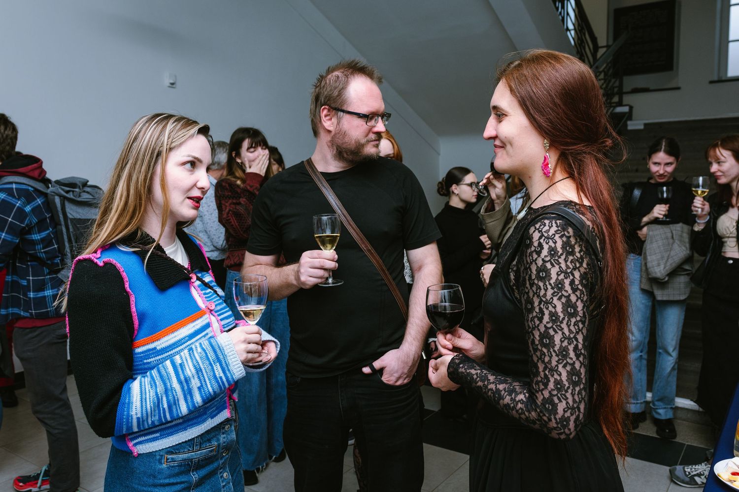 People engaged in lively conversation at an indoor social gathering.