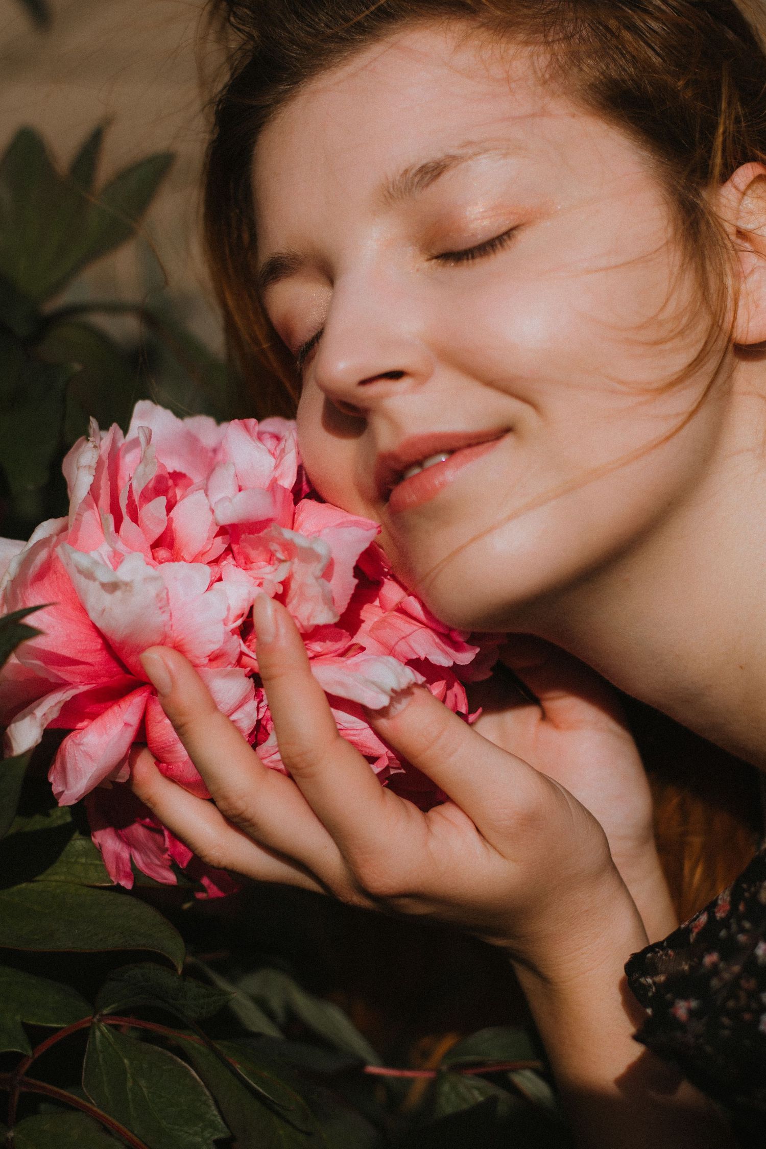 Artistic close-up shots of pink flowers being held and smelled.