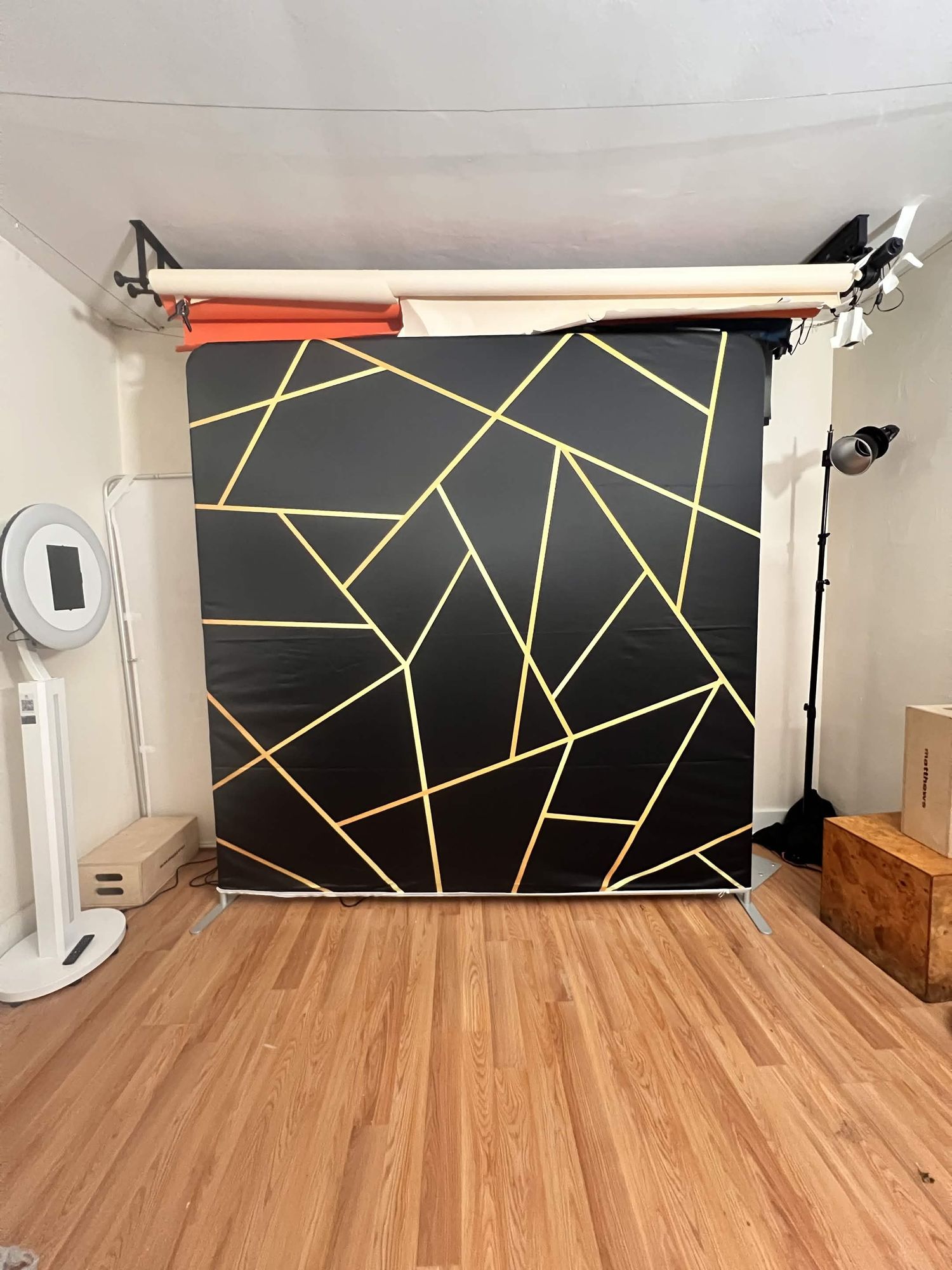 A bold black and gold geometric pattern photography backdrop for studio photo booths.