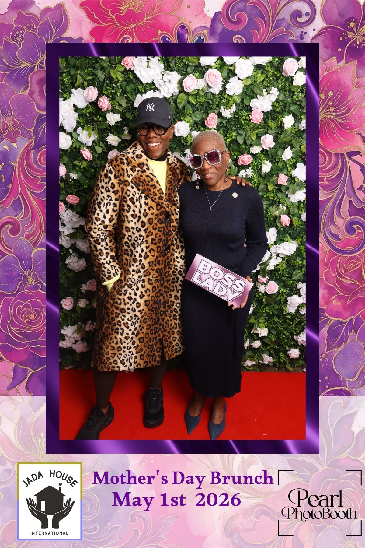 Two women pose at a Mother's Day Brunch photo booth with a floral backdrop on May 1st 2026.