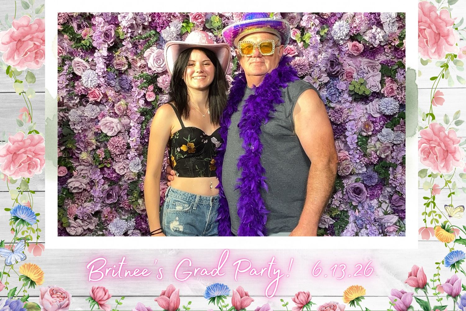 Two party guests pose in front of a purple floral wall at Balnee's Grad Party on June 19, 2024.