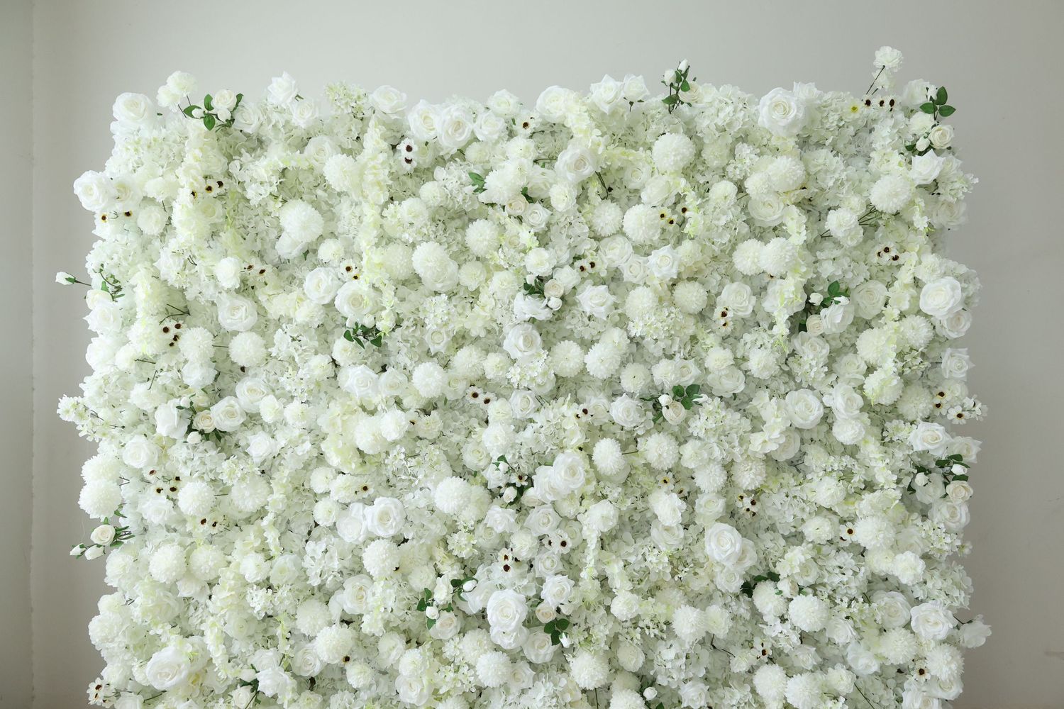 Lush white flower wall backdrop featuring roses and baby's breath, perfect for weddings and events.