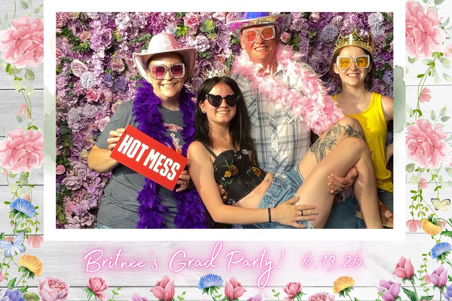 Four friends pose at Belnee's Grad Party on 6.19.24 in front of a floral wall backdrop.