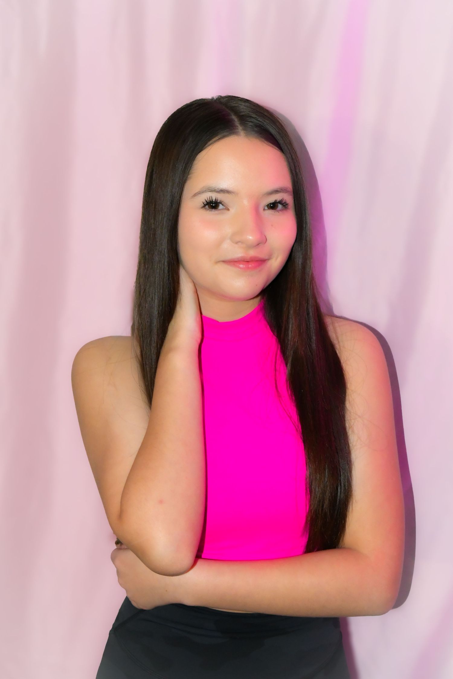 Soft studio portrait of a dancer in pink with relaxed, elegant pose on a pink background