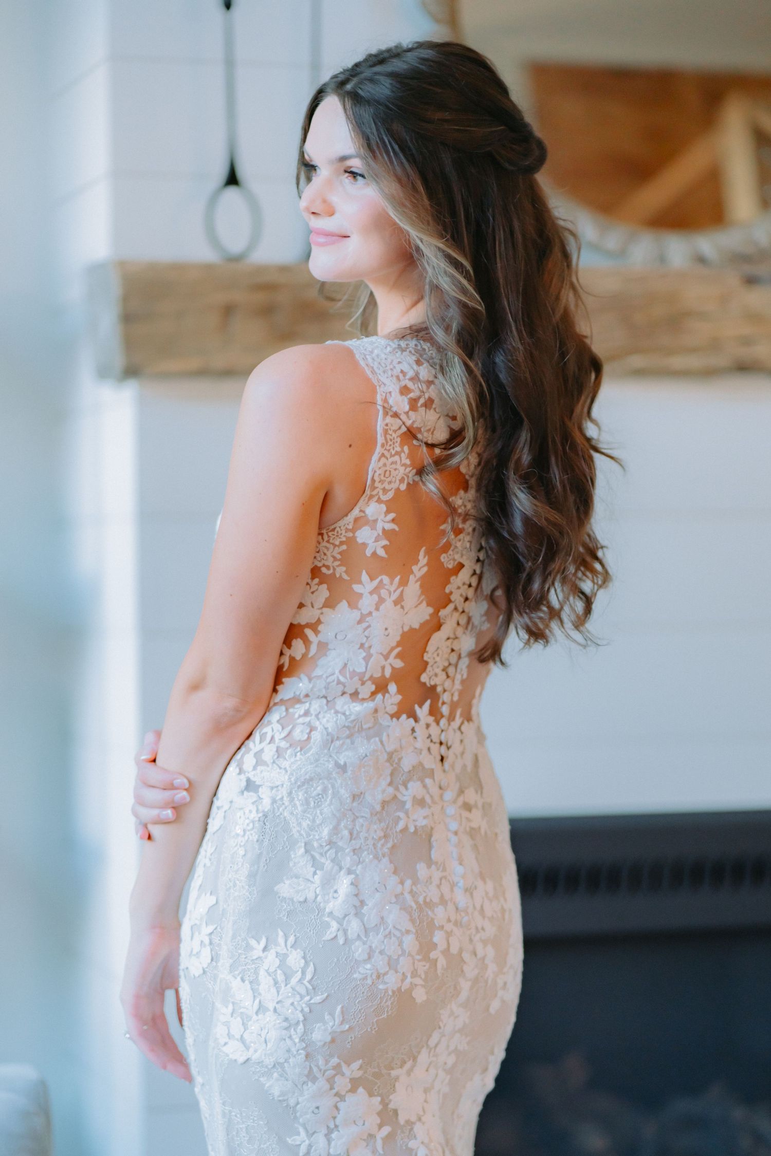 Back view of fitted lace wedding gown showing intricate floral pattern details.