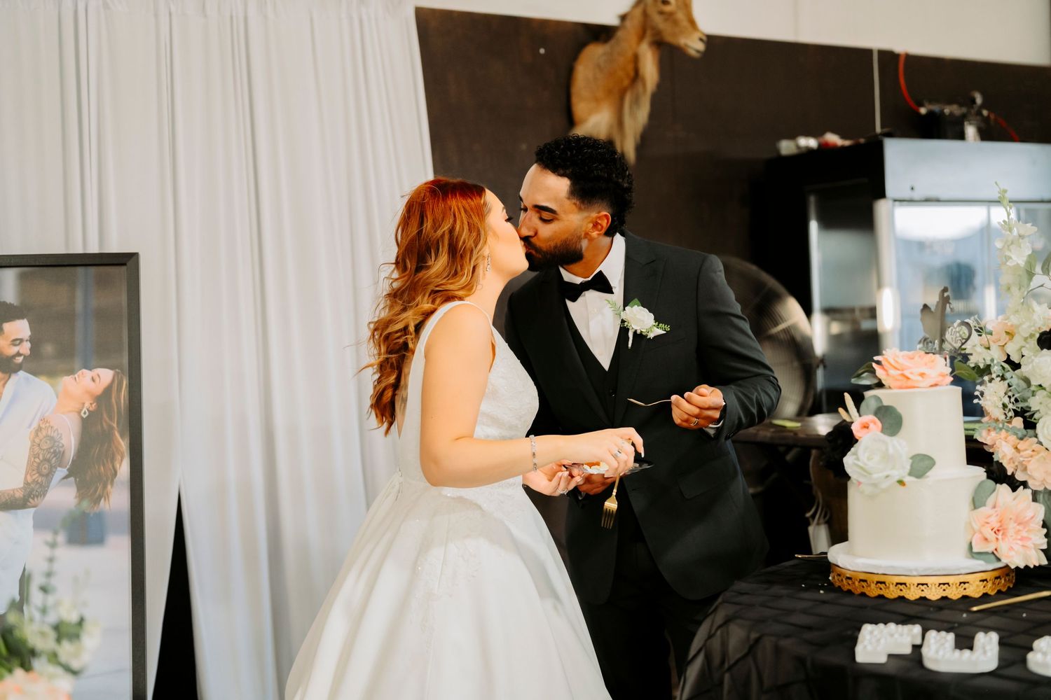 A couple sharing a sweet moment while cutting their wedding cake at their reception.