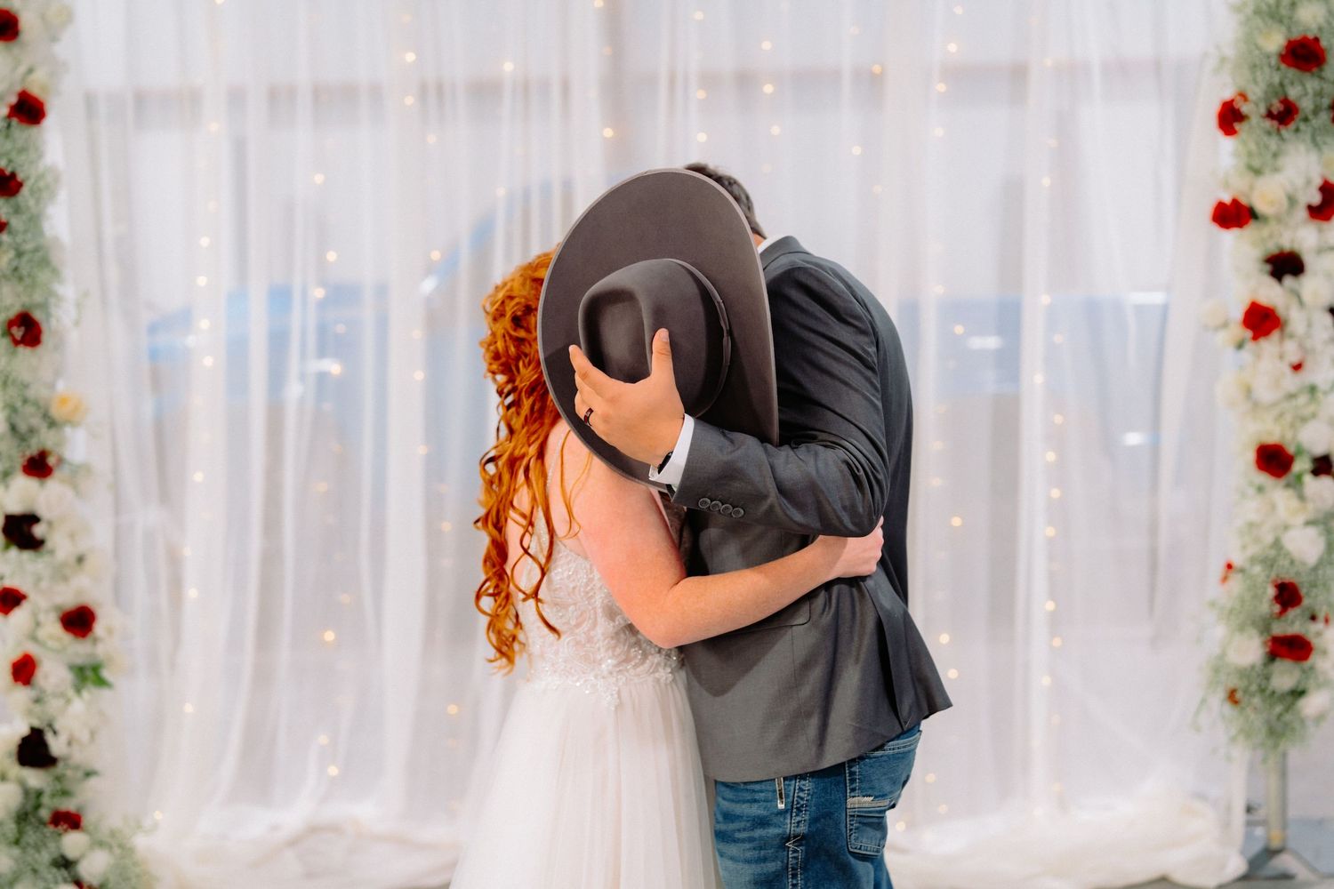 Romantic western-themed wedding dance with couple embracing under fairy lights.