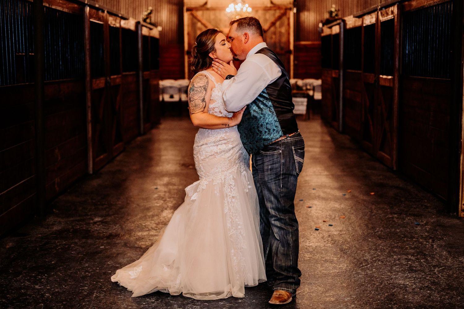 Bride and groom share intimate dance moment in rustic barn venue.