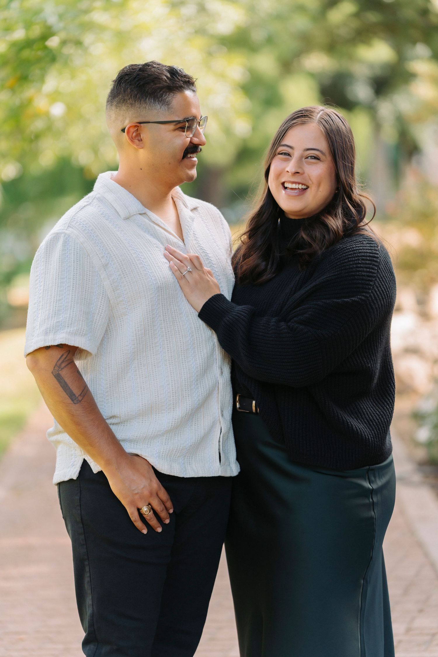 A couple shares a joyful moment together while embracing outdoors on a sunny day.