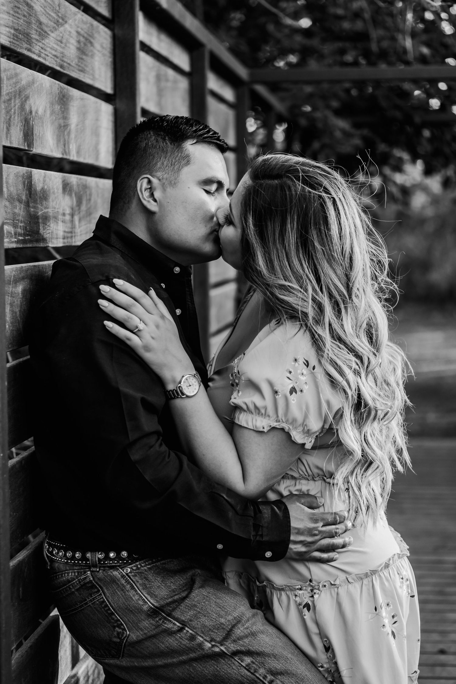 A couple embraces in a romantic outdoor setting with soft lighting.