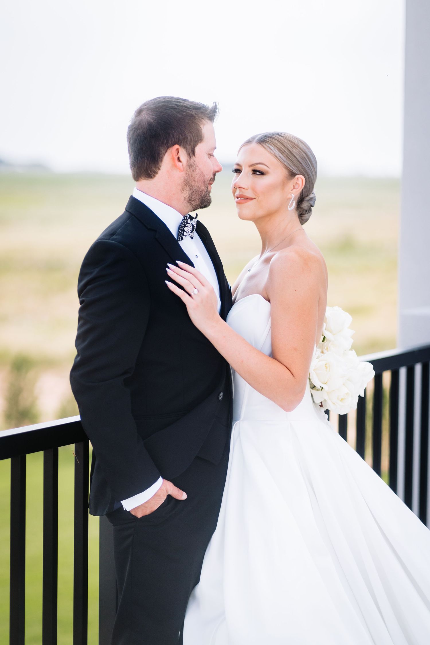 A loving wedding portrait captured on an outdoor terrace.