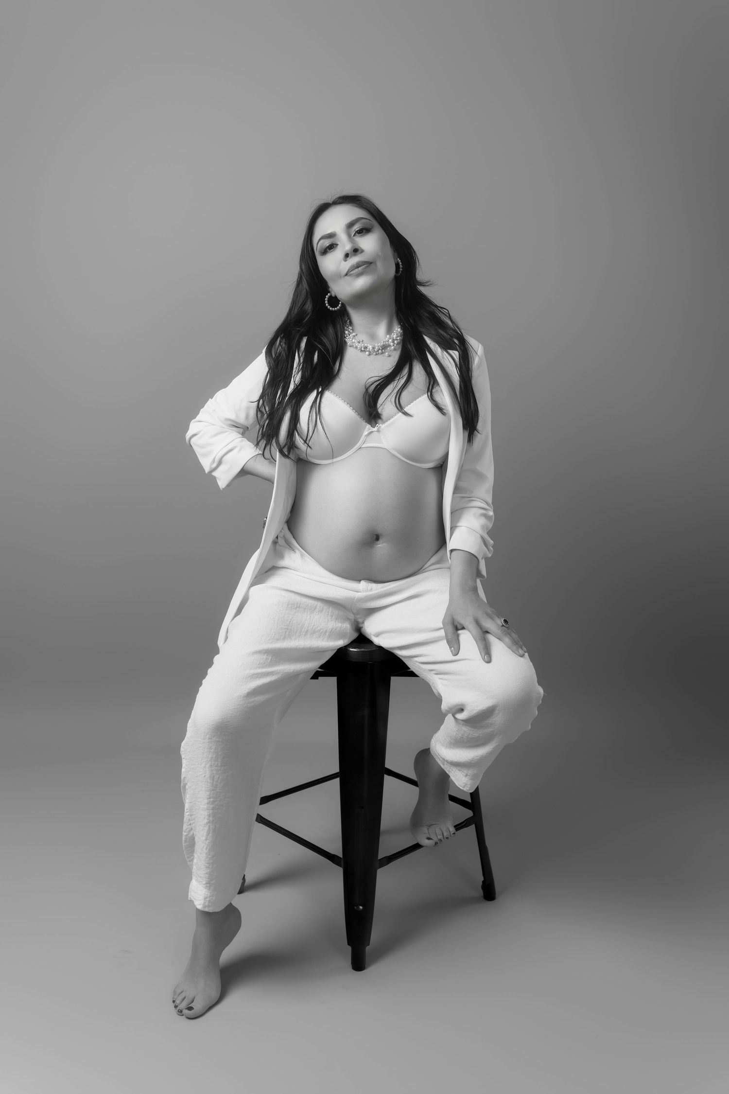 Artistic maternity portraits with white clothing showing dynamic seated poses.