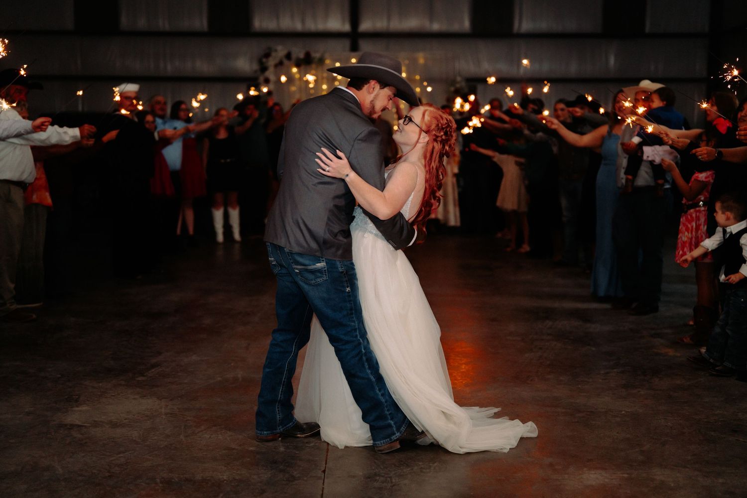 Evening wedding celebration with couples dancing under ambient lighting.