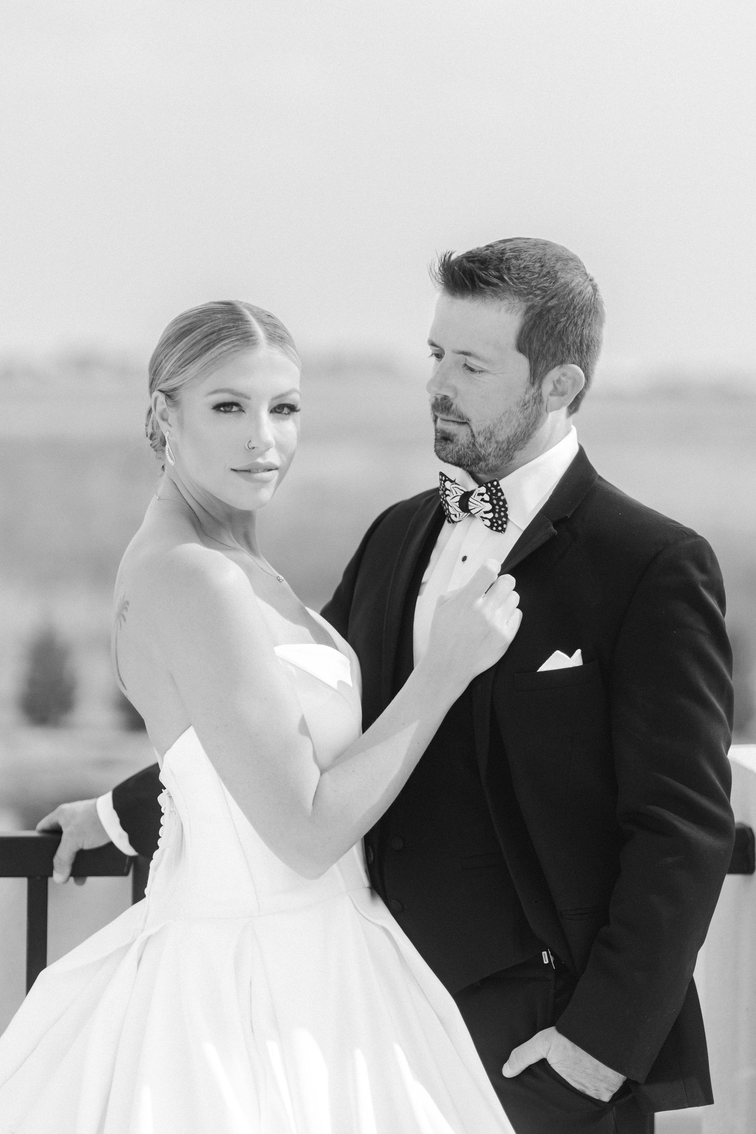 An elegant black and white portrait of a couple in formal wedding attire.
