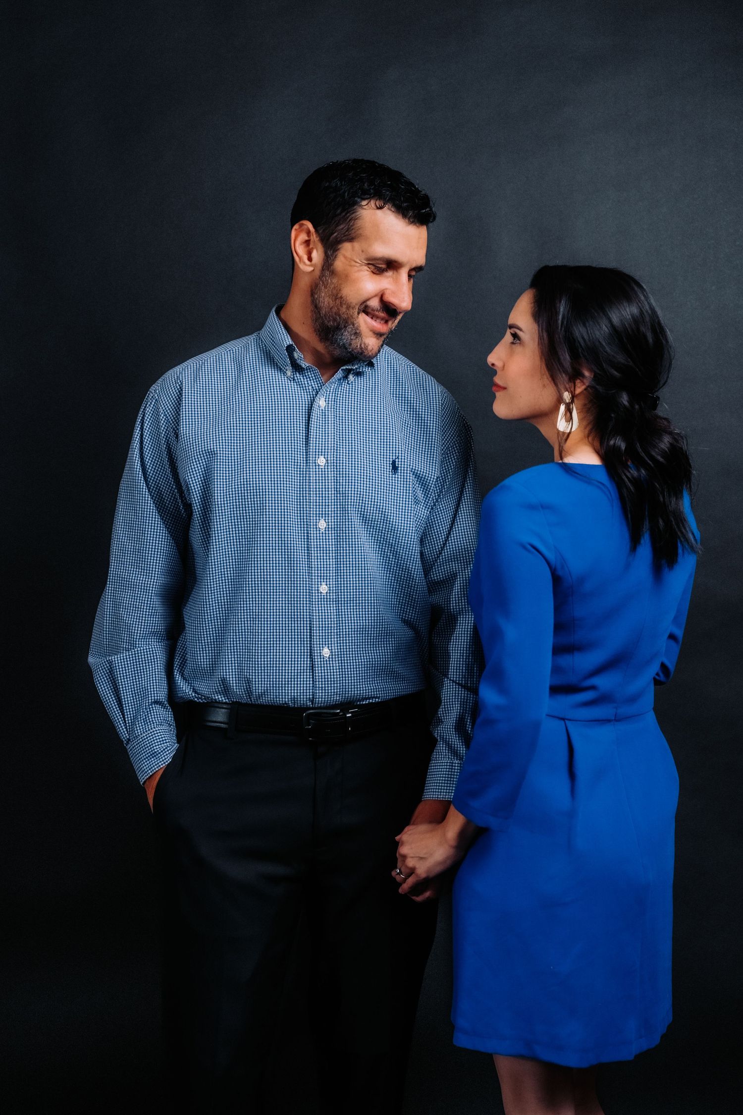 Candid moment between couple in blue attire during professional photo session.