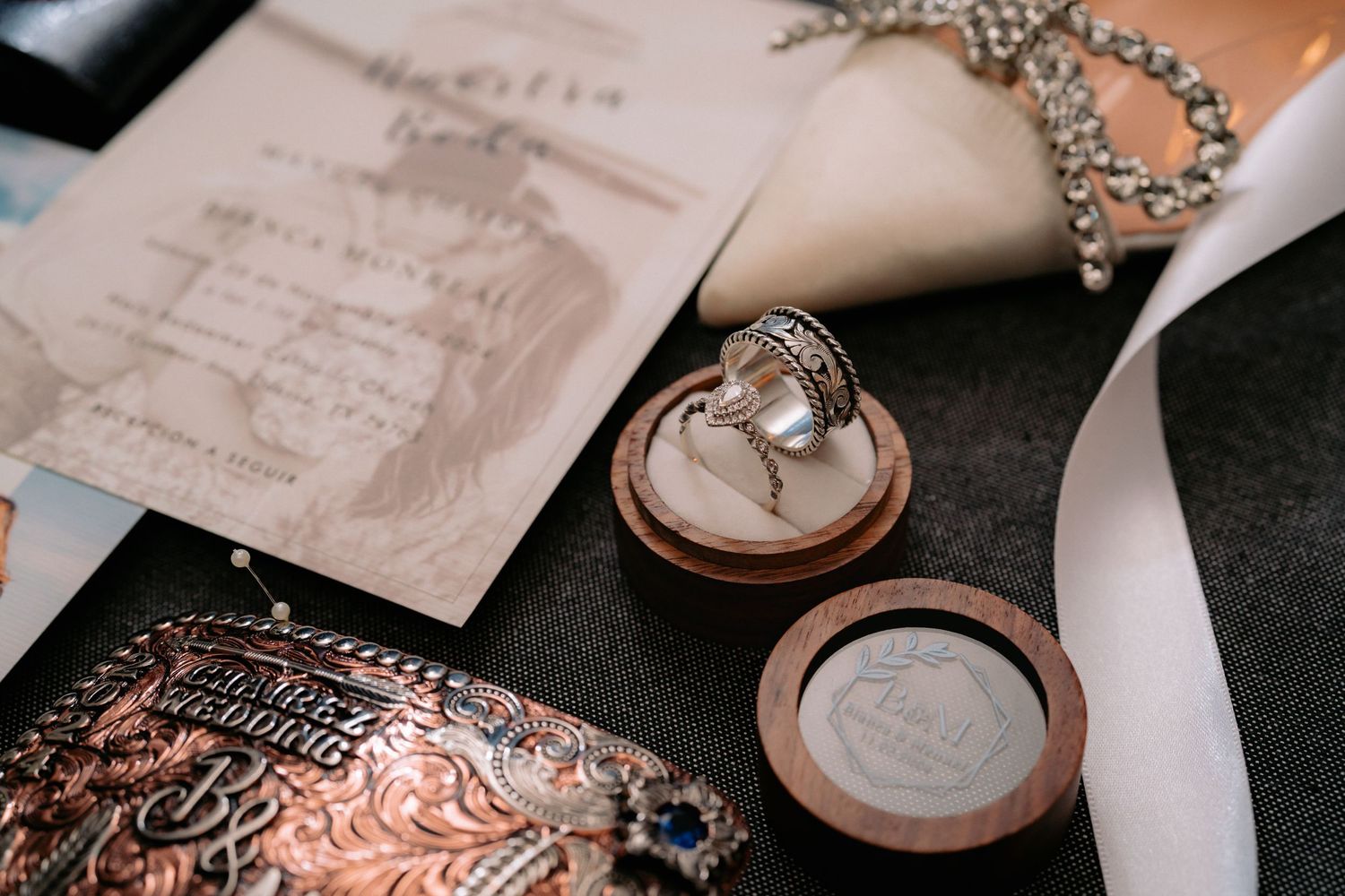 Wedding rings displayed with invitation and decorative accessories.