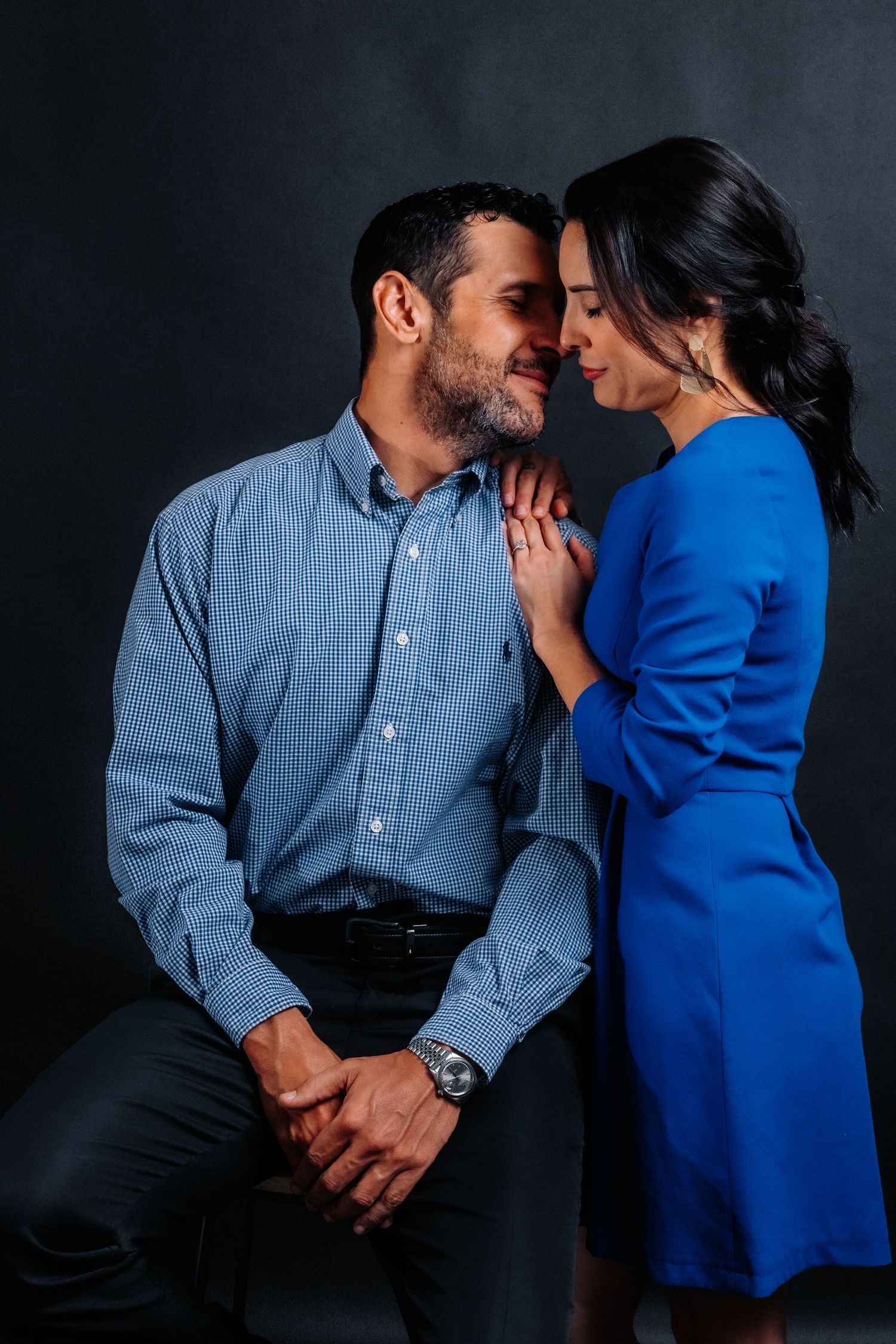 Intimate moment between couple in blue clothing during professional photo session.