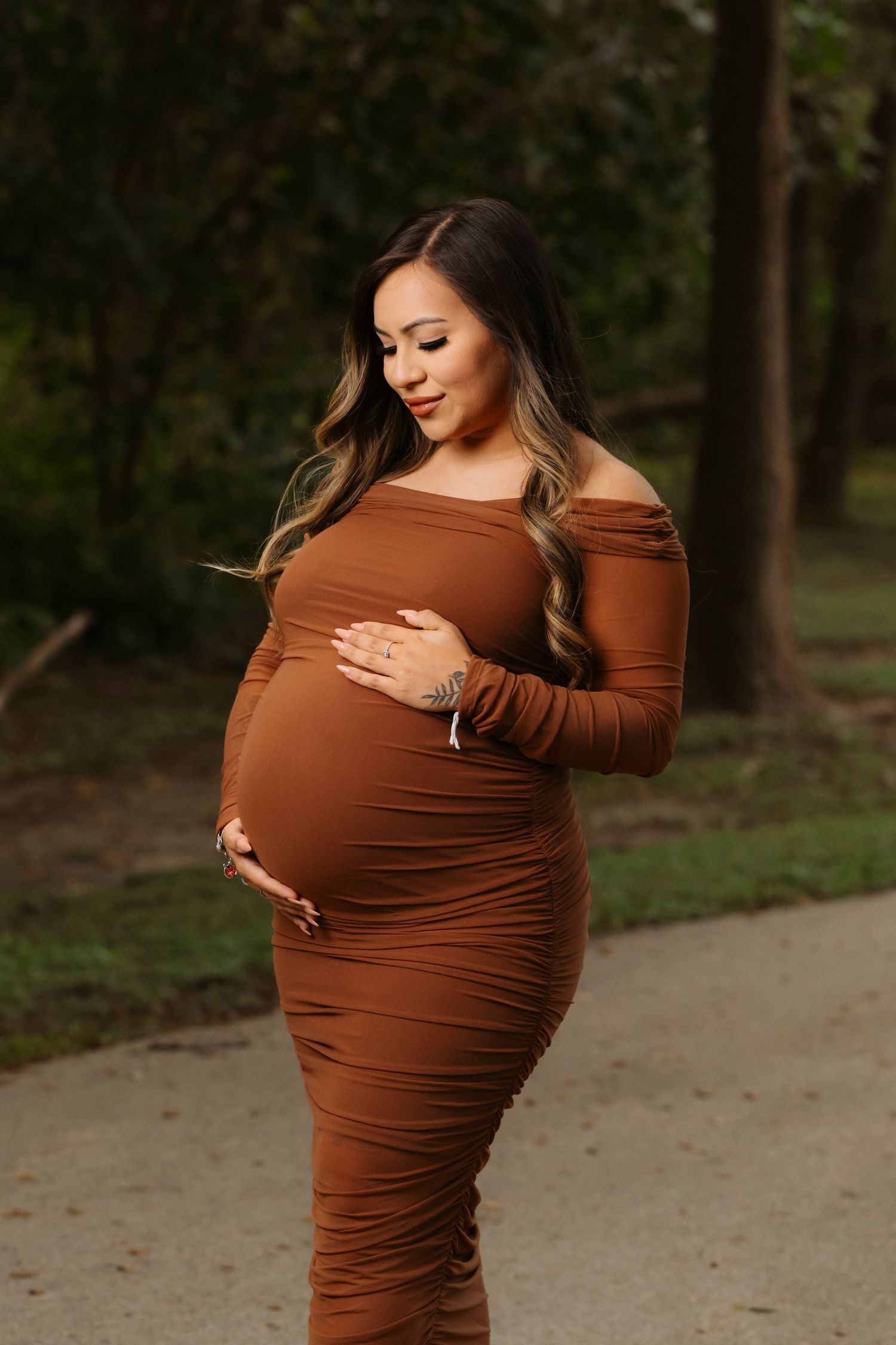 A series of photos showing a pregnant woman in a brown dress cradling her baby bump while standing outdoors.