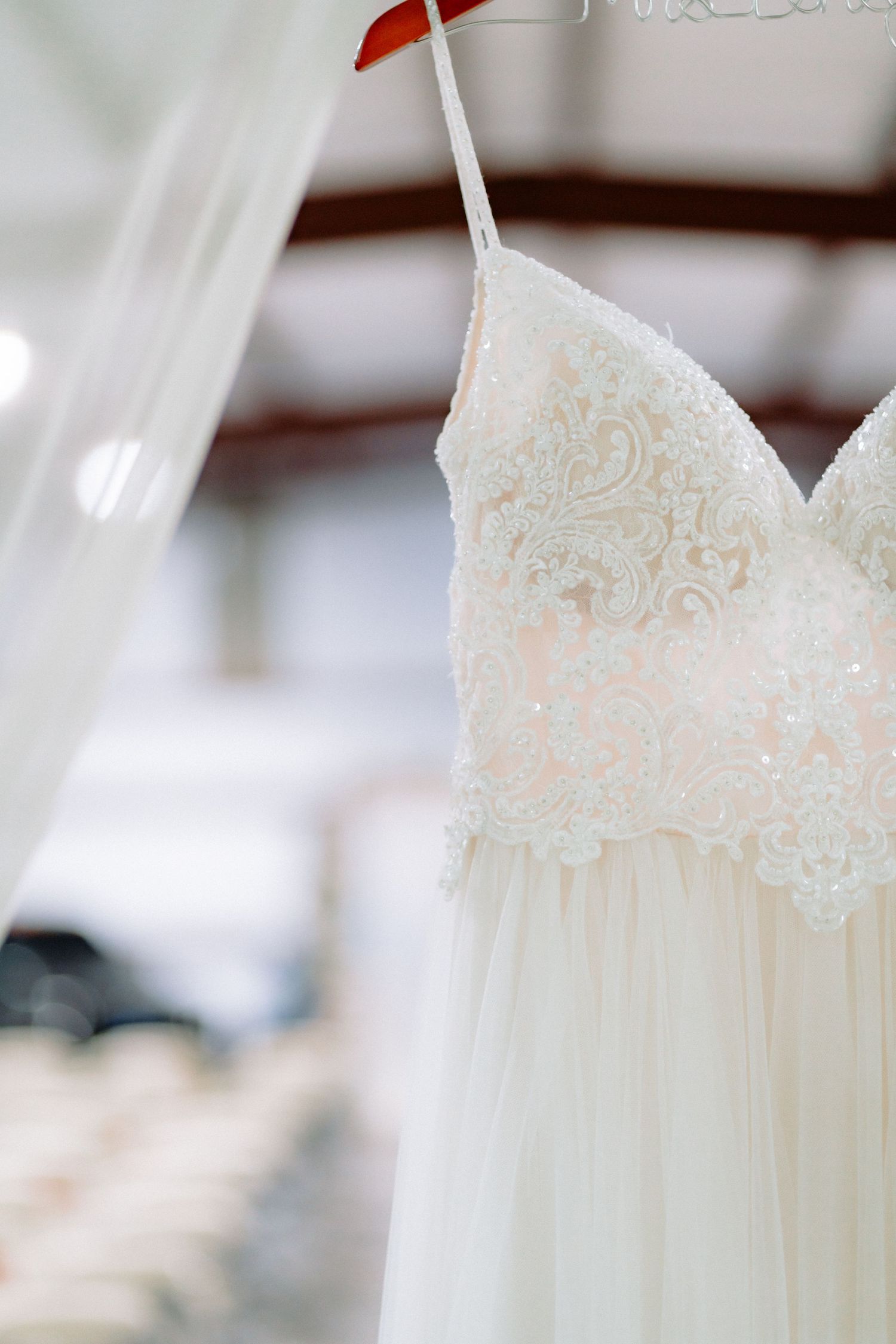 Close up of delicate lace bodice on white wedding gown showing intricate pattern details.