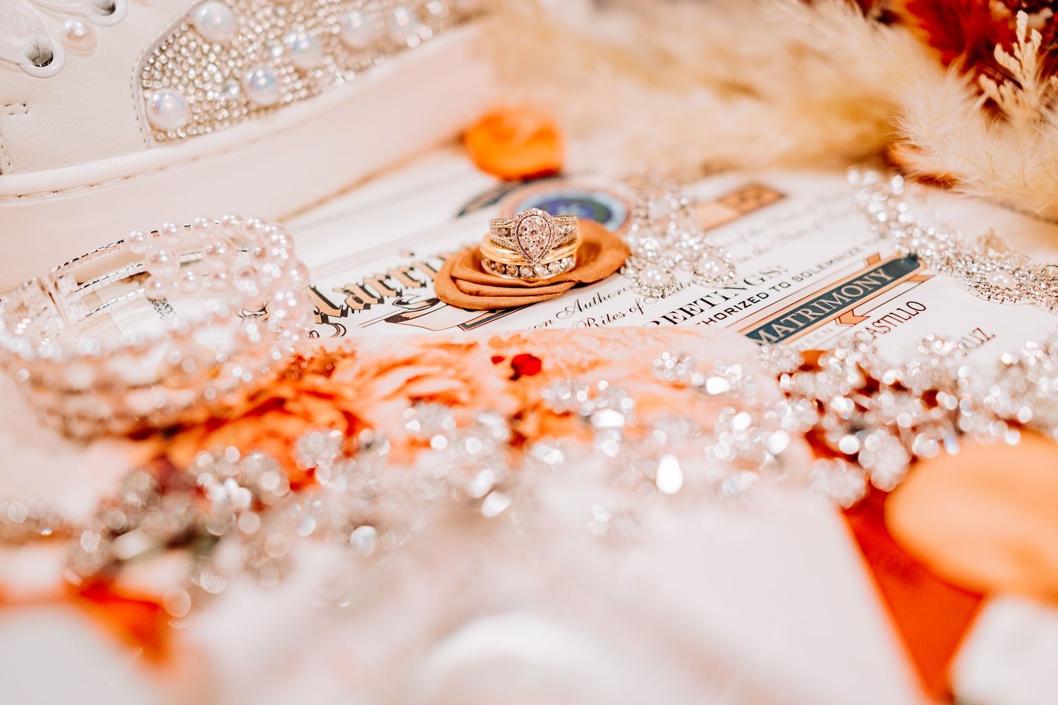 Romantic wedding stationery and accessories with warm orange lighting effects.