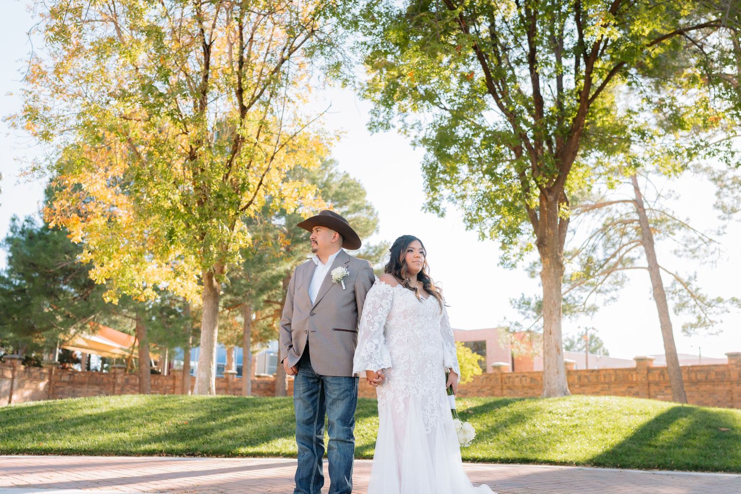 Romantic outdoor wedding portraits with sunlit trees and green lawns.