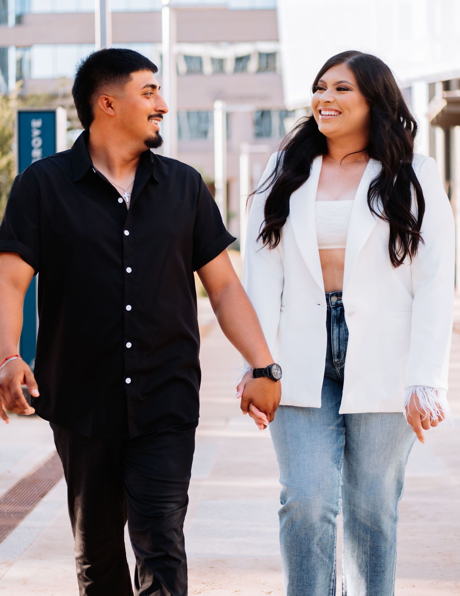 Stylish couple in casual outfits share happy moment walking together in urban setting.