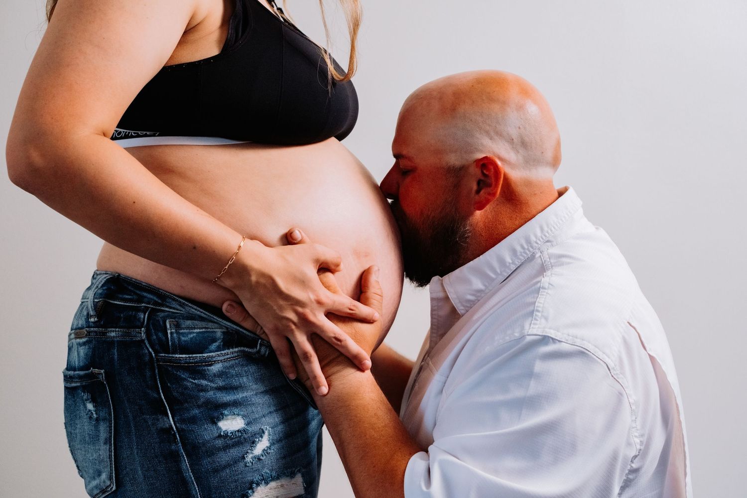 Close-up shots capturing intimate moments during a pregnancy photoshoot.