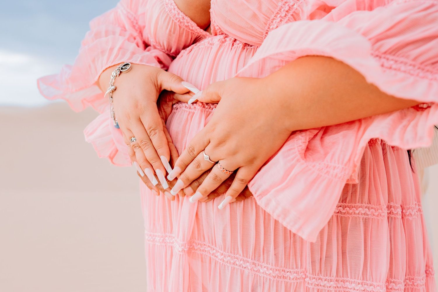 Close-up shots of coral dress details against desert landscape.