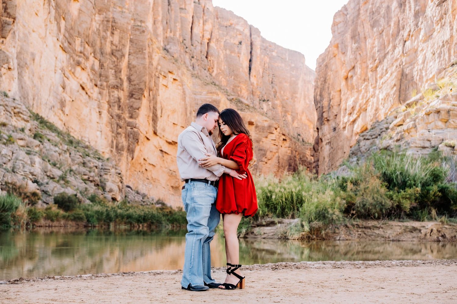 A couple shares romantic moments against stunning canyon walls and desert landscapes.
