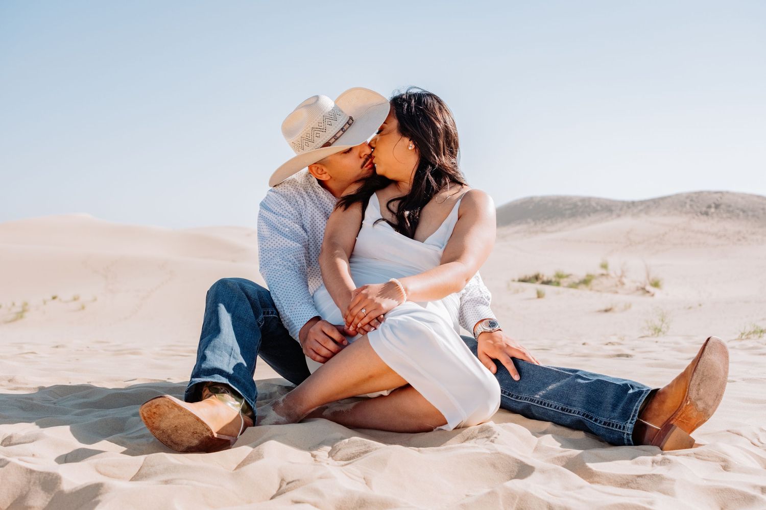 Sweet couple enjoys tender moments together on sandy beach during photo session.