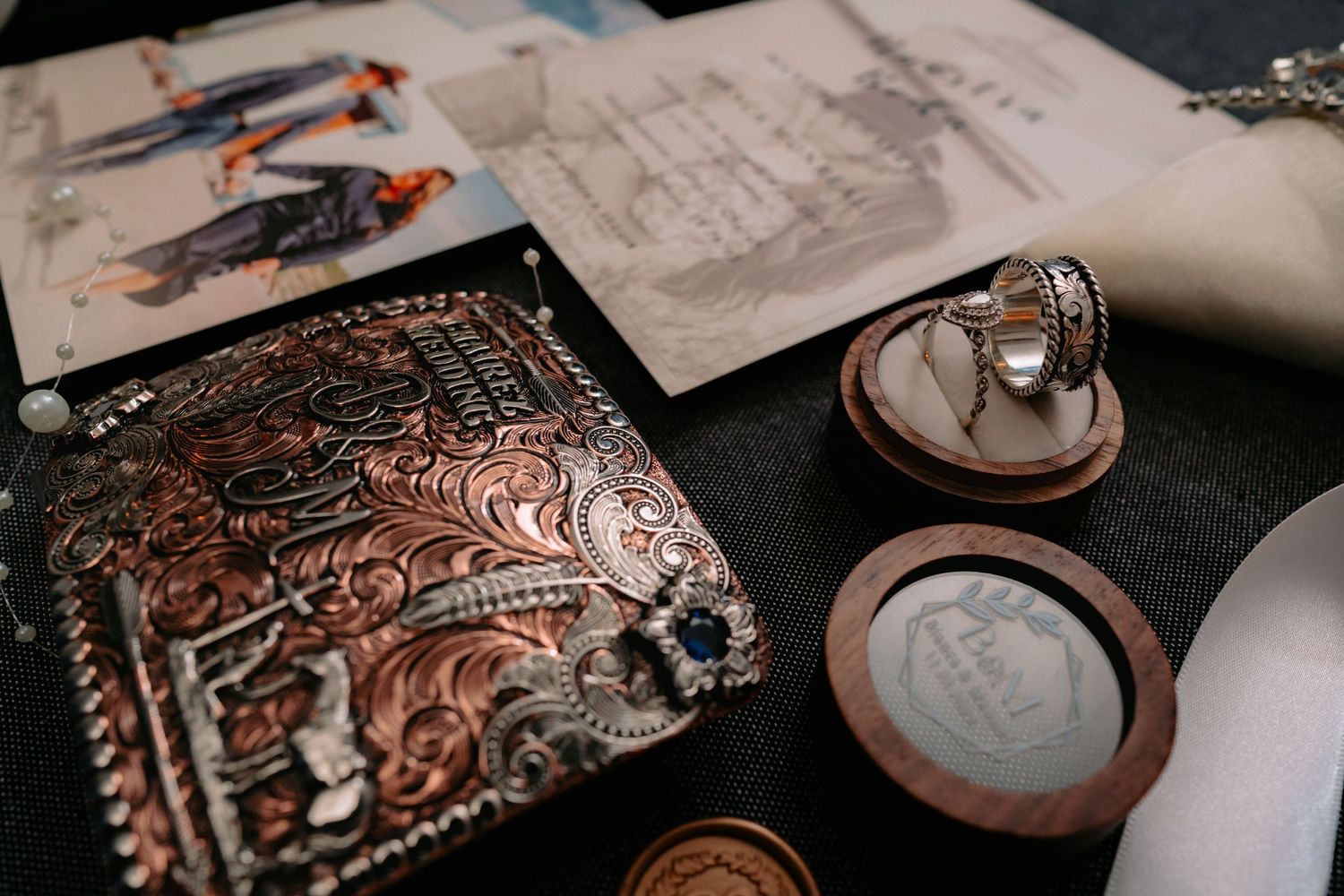 Detailed shot of ornate invitation suite with wooden ring boxes.