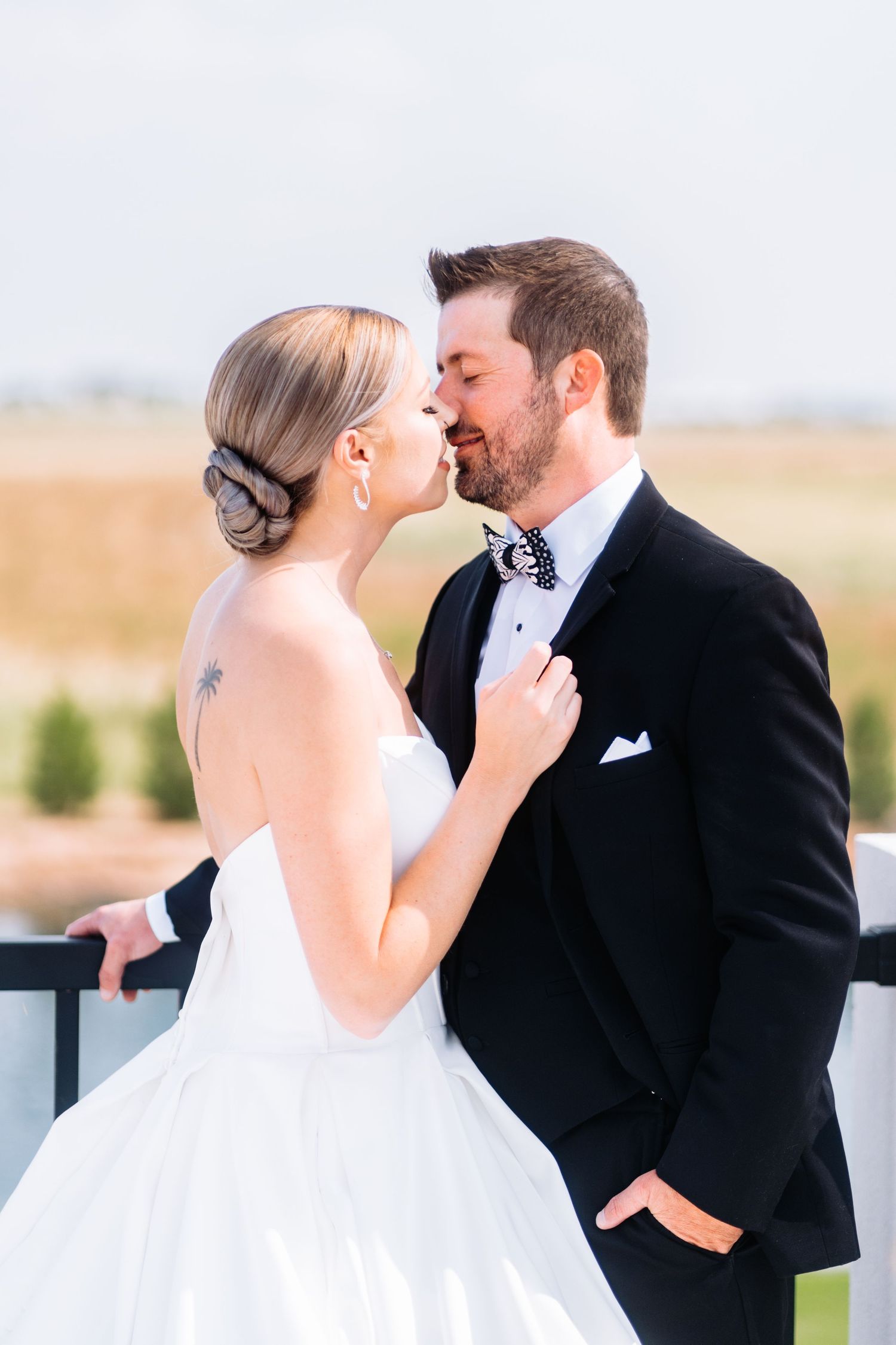 A tender moment between a couple on their wedding day on an outdoor balcony.