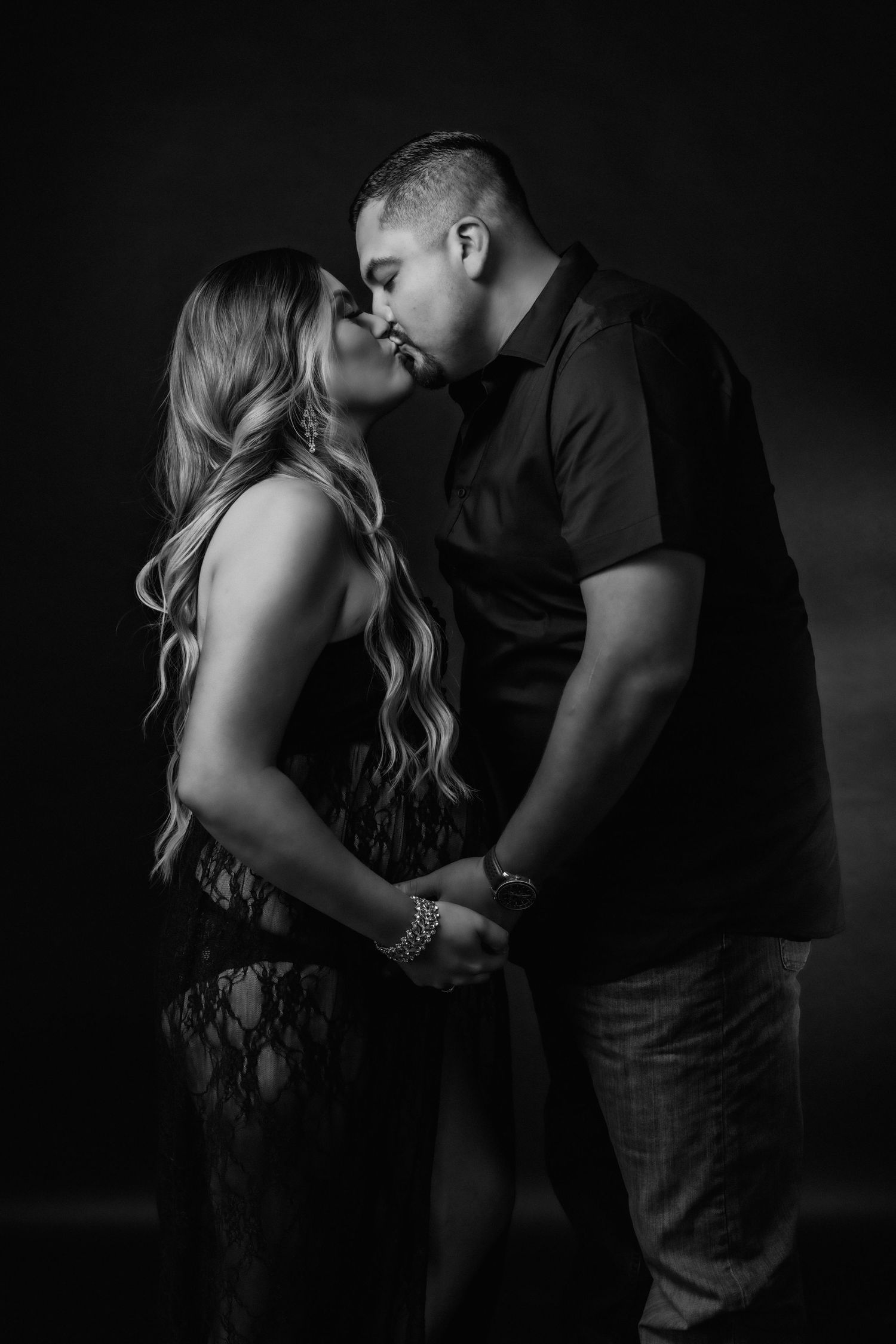 Black and white maternity photos showing tender couple moments in studio.