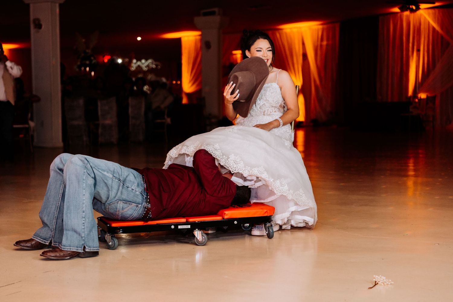 Fun wedding reception dance floor moments captured in warm ambient lighting.