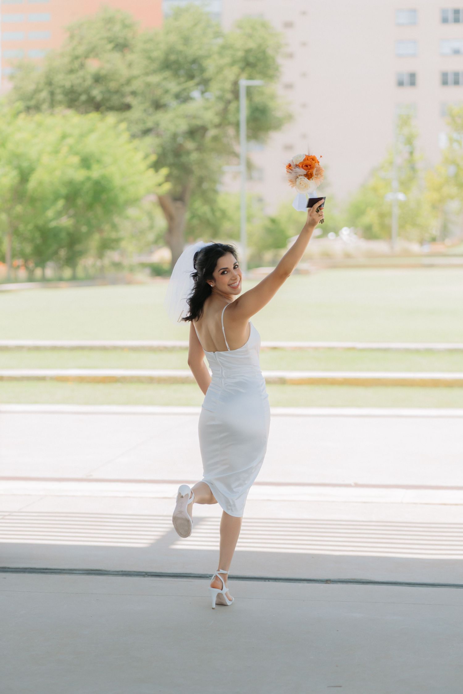 A bride celebrates her wedding showing off her bouquet in Midland Texas