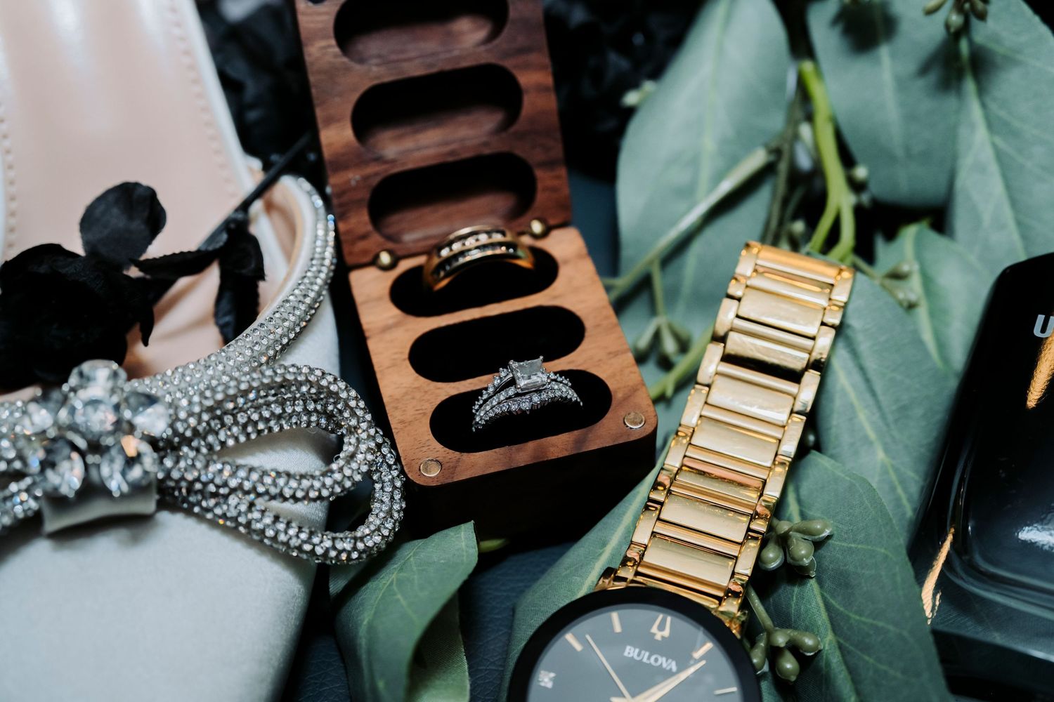Wedding accessories including flowers, jewelry and watches arranged artistically.