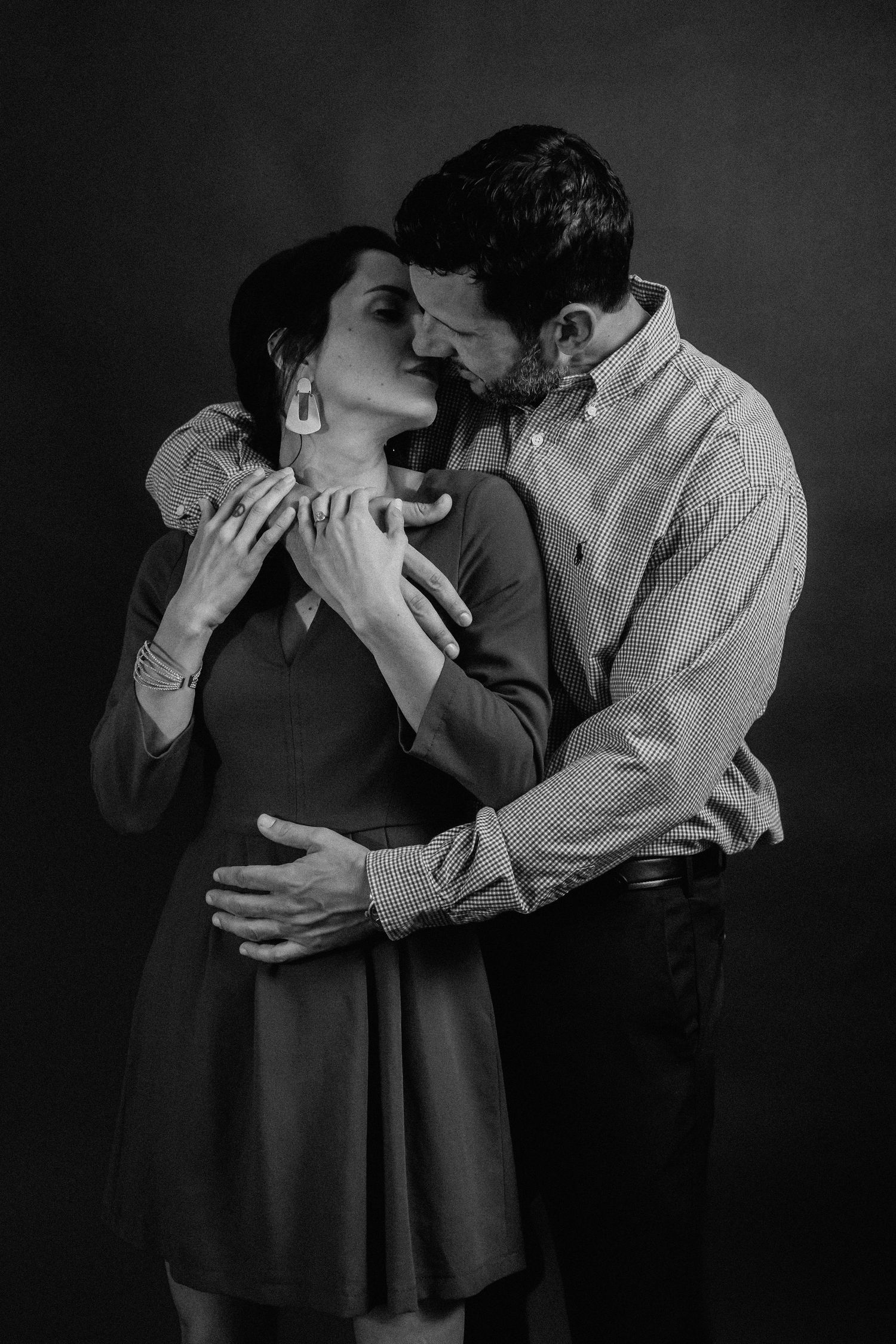 Artistic black and white portrait of couple in intimate embrace.