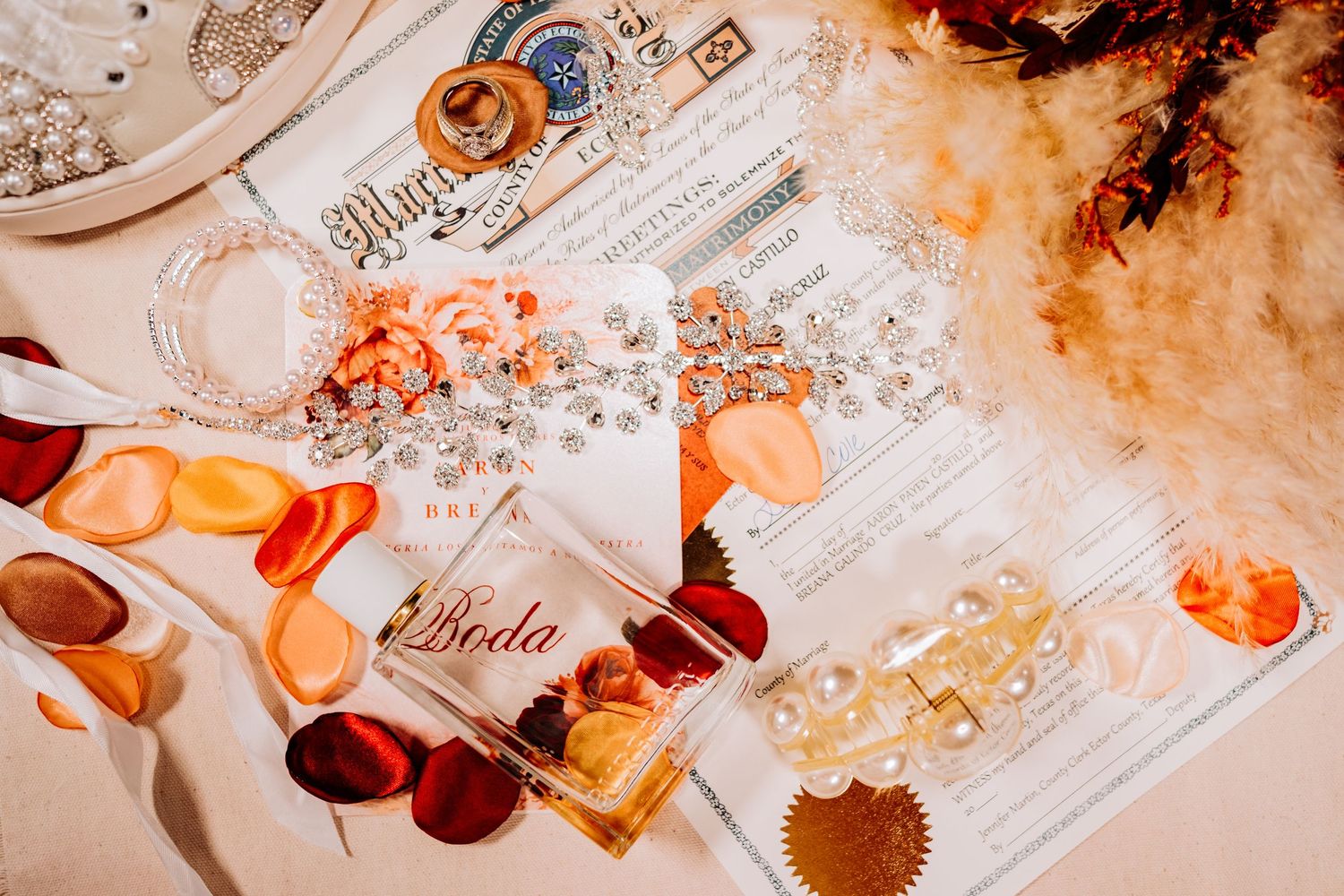 Artistic wedding details flatlay with orange and golden tones.