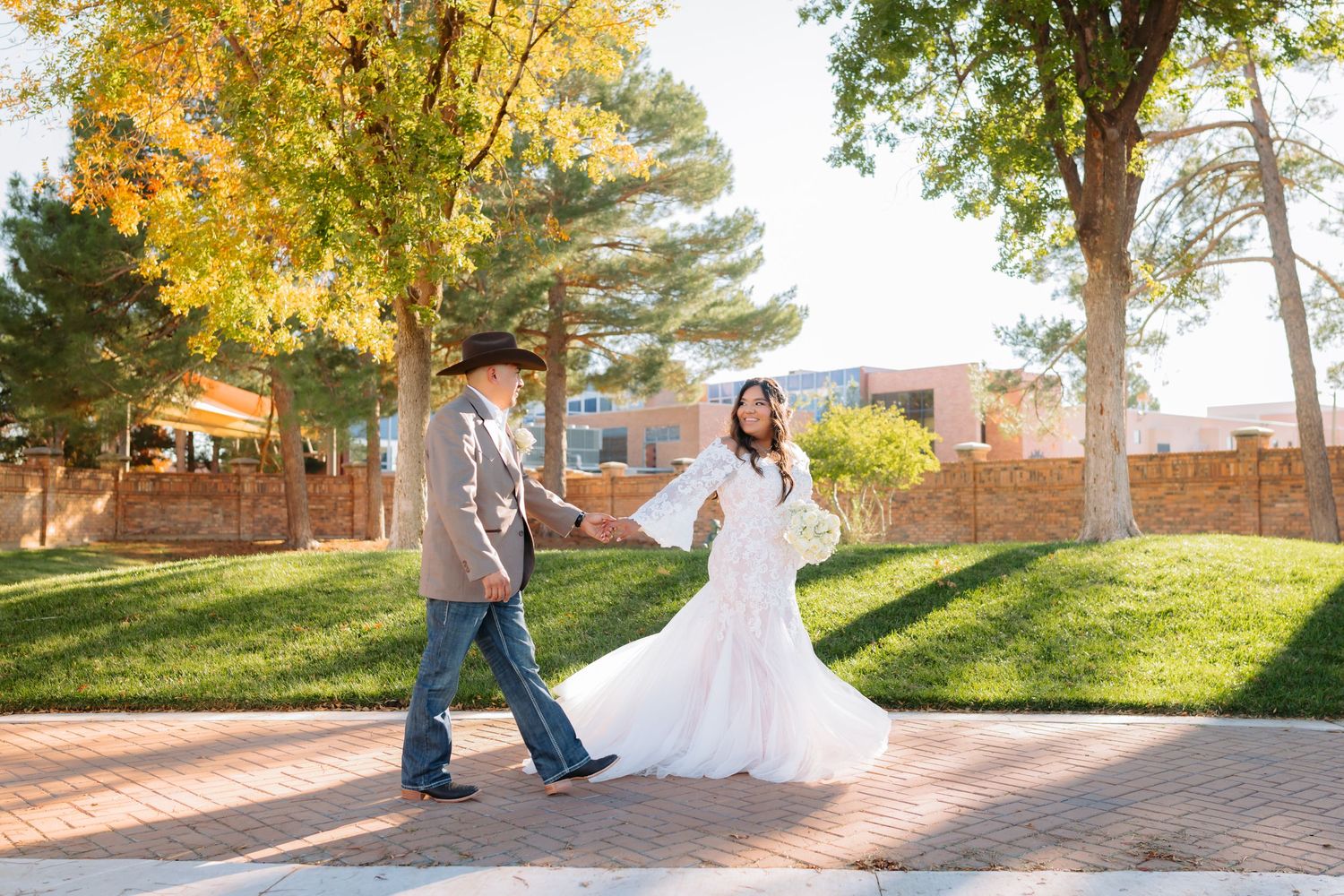 Wedding couple photographs taken on a brick pathway during golden hour.