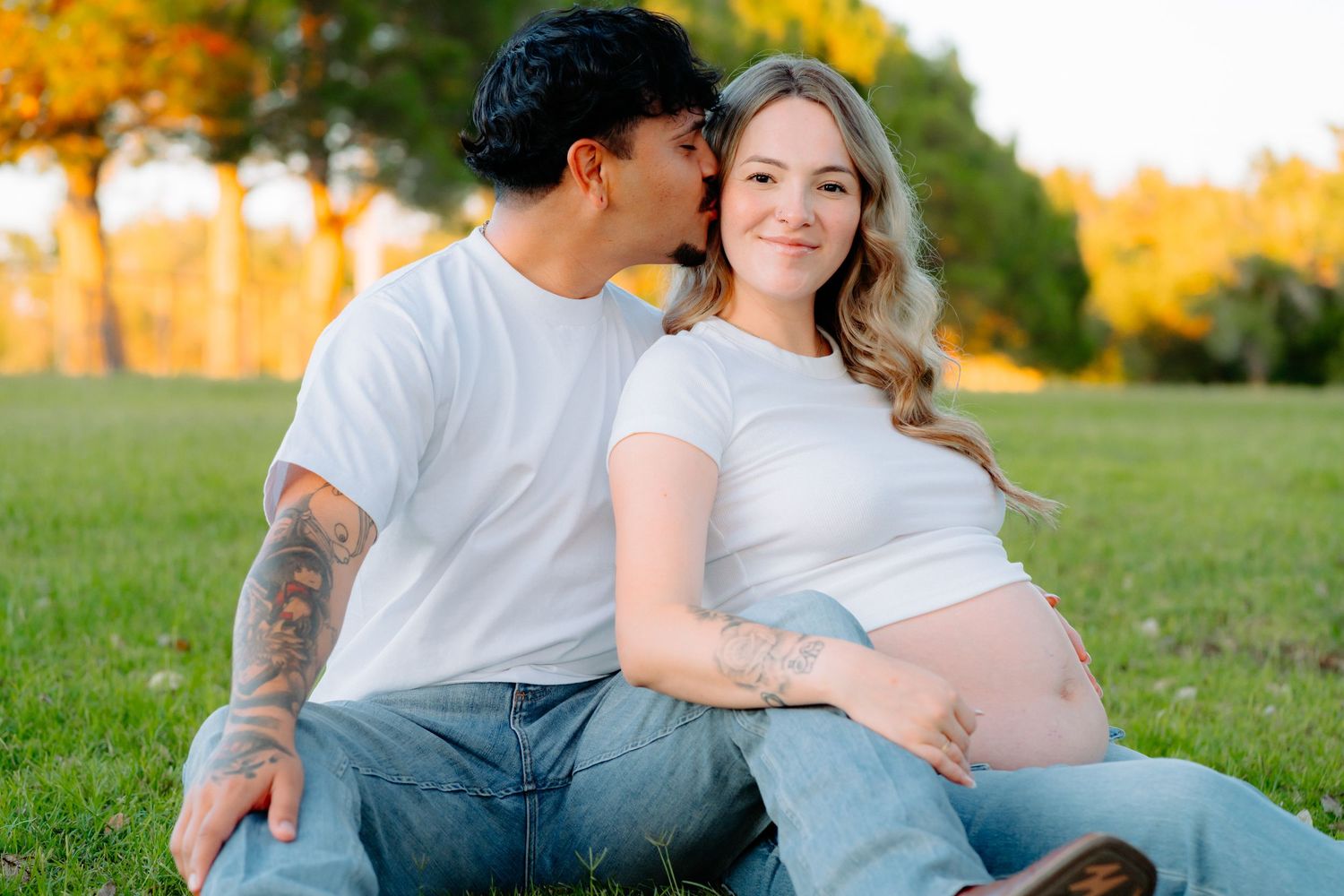 Romantic outdoor photoshoot featuring couple in coordinated outfits against golden autumn backdrop.