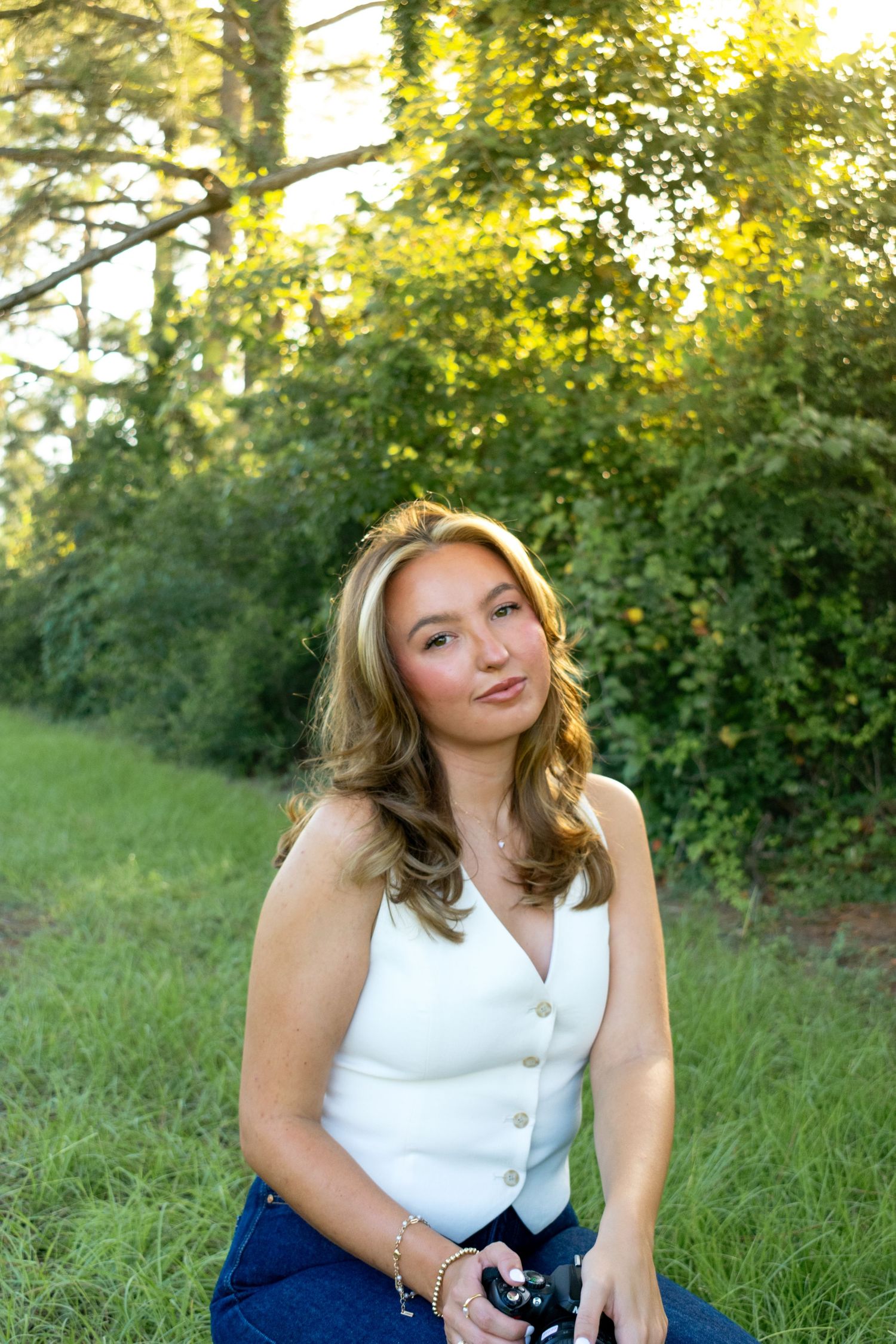 Girl sitting in field during golden hour.