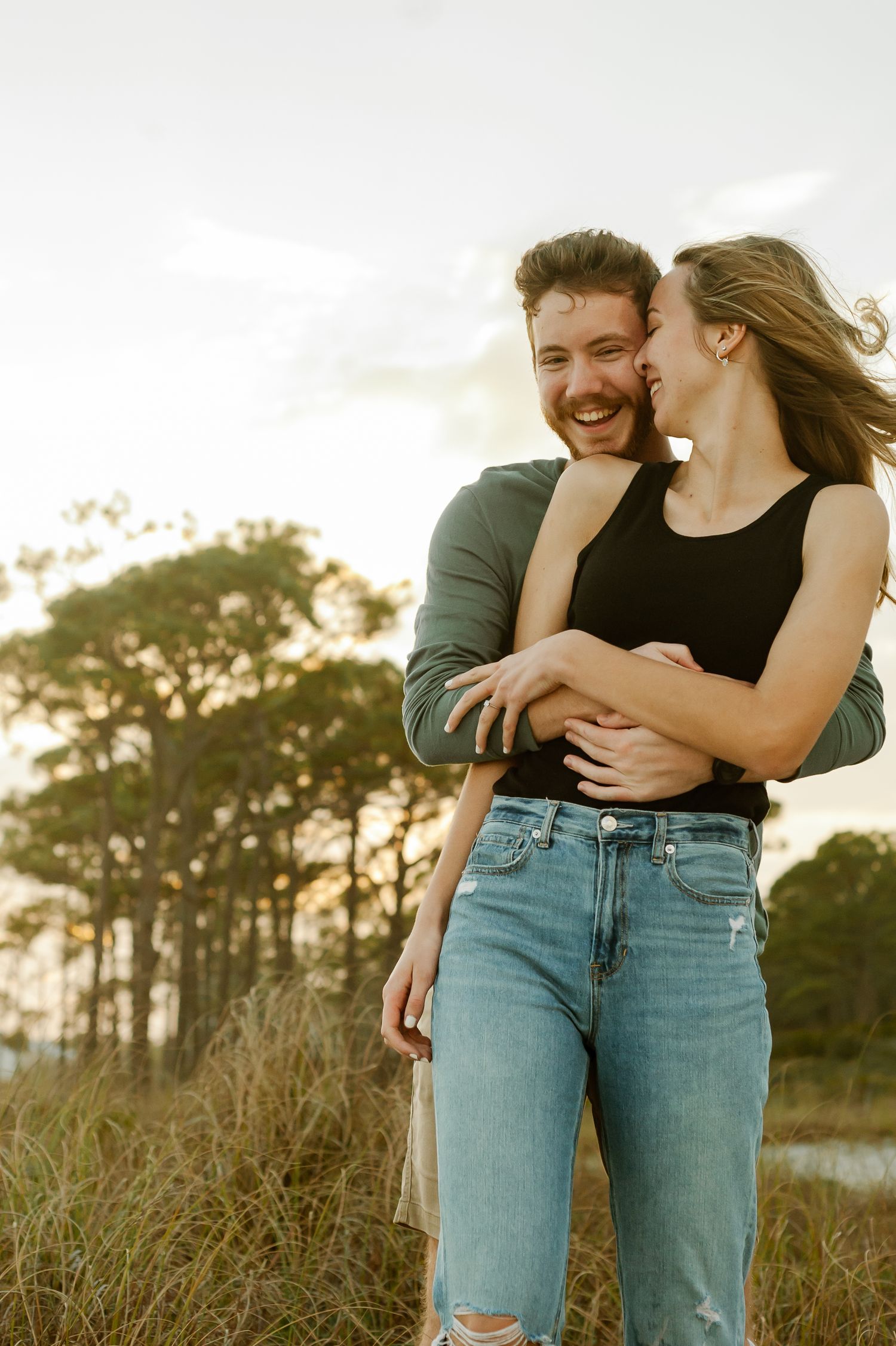 A loving embrace captured during golden hour in a natural outdoor setting.