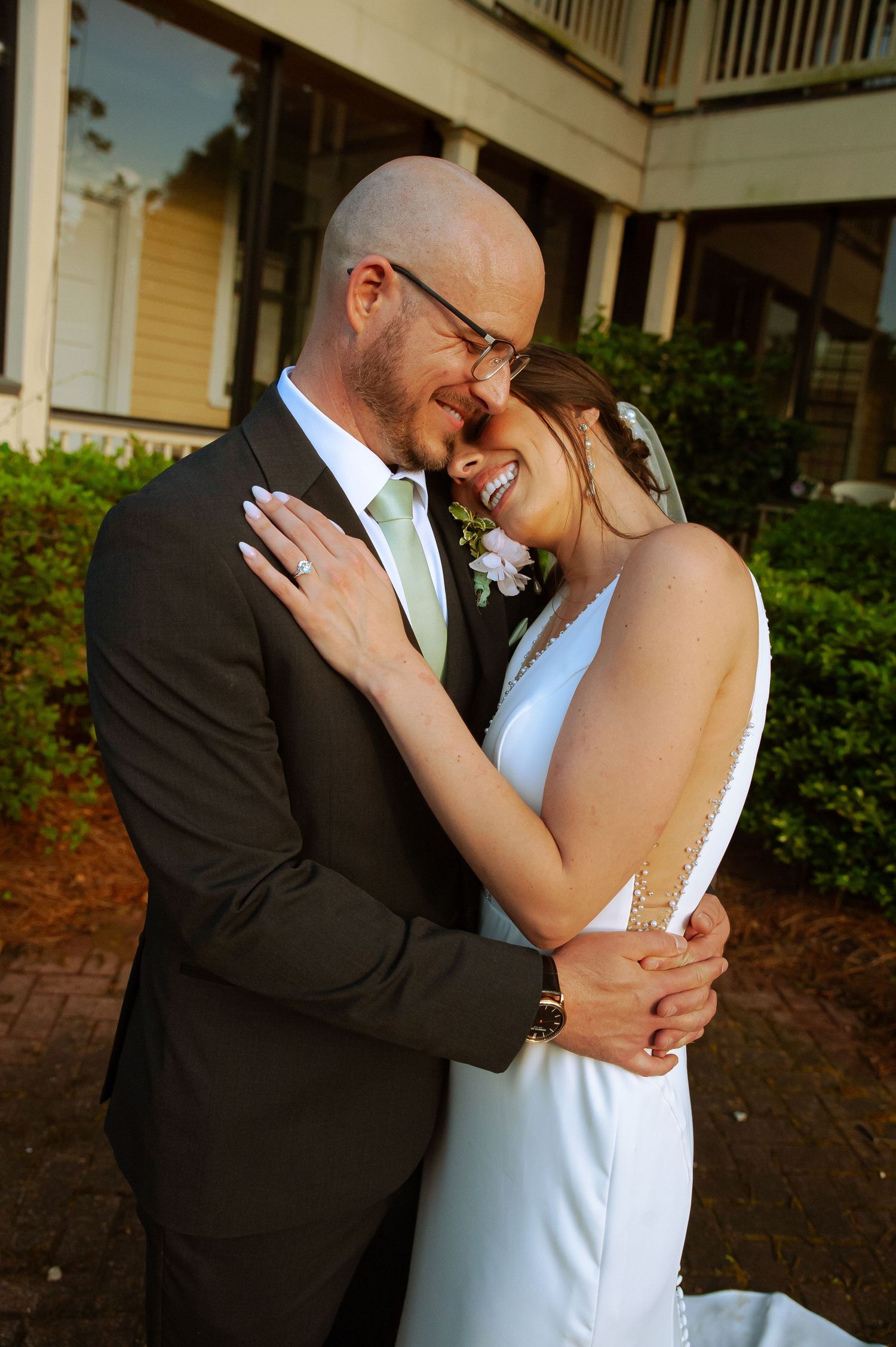 A tender wedding portrait captured on a porch with soft natural lighting.