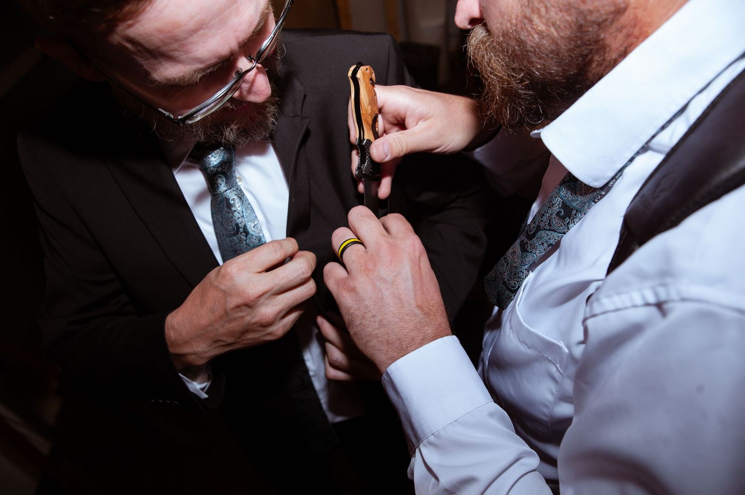 Professional barber uses straight razor to trim and shape beard at traditional barbershop.