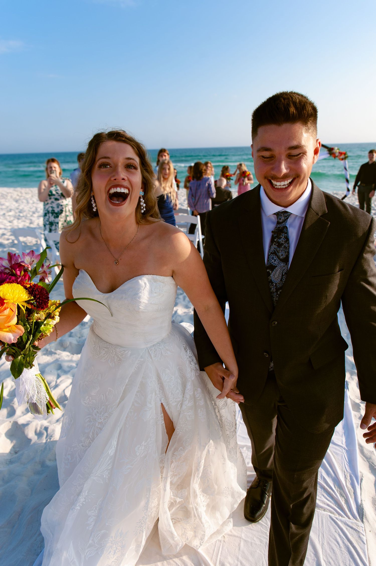 Joyful beach wedding celebration sequence showing candid moments of laughter and happiness on a sunny shoreline.