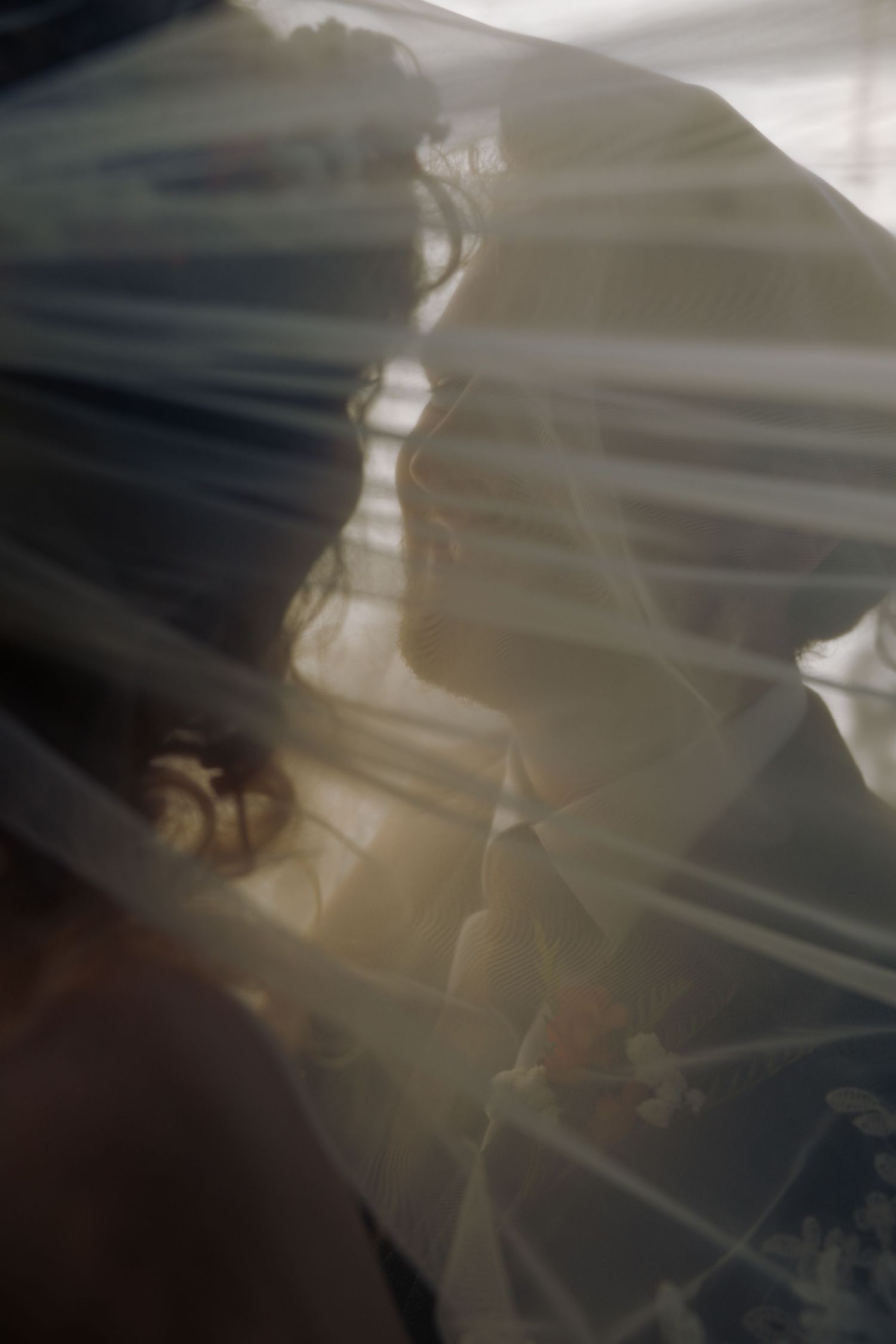 An ethereal artistic shot through flowing white bridal veil fabric.
