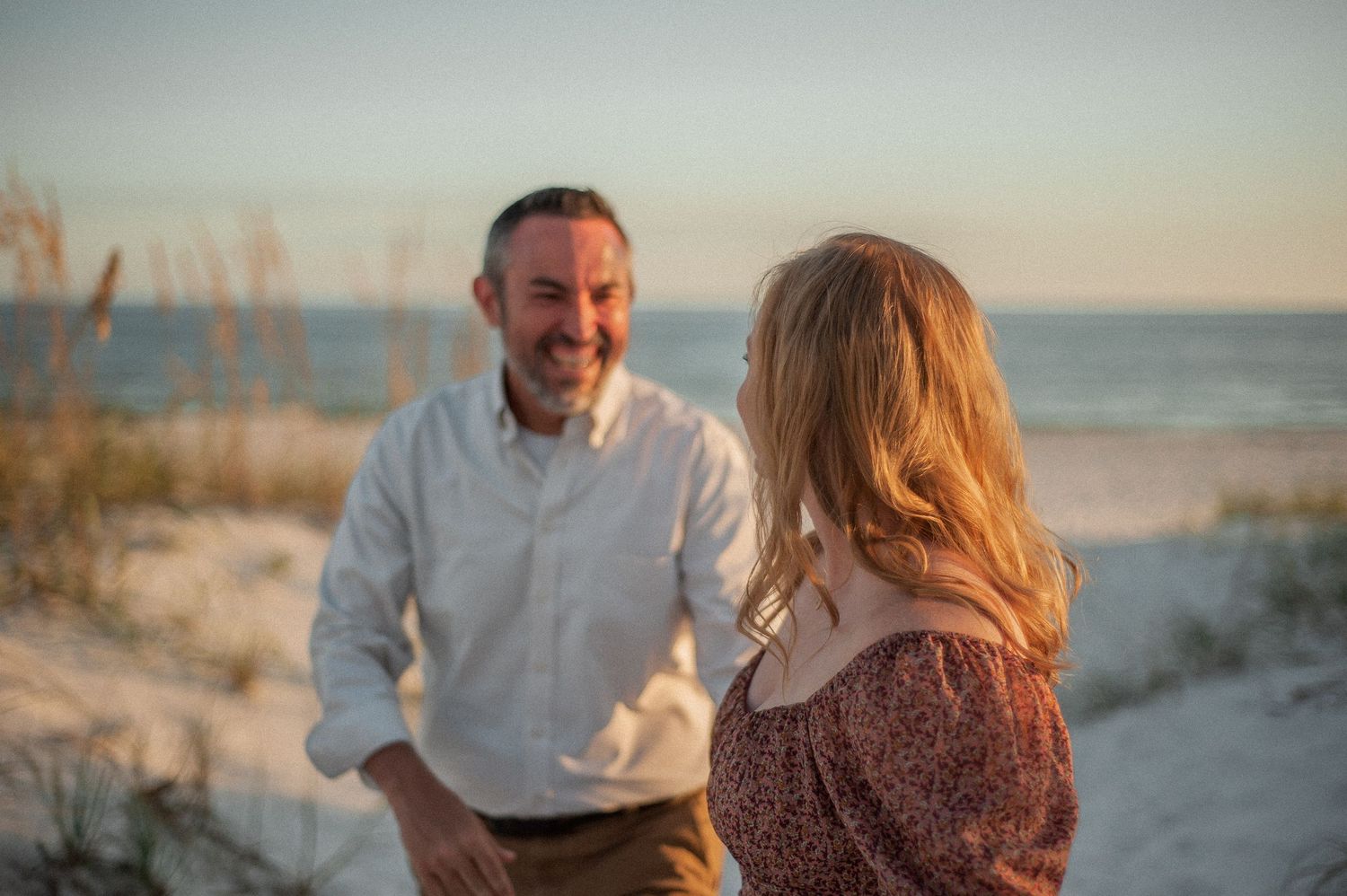 A romantic beach photoshoot at sunset with soft golden lighting.
