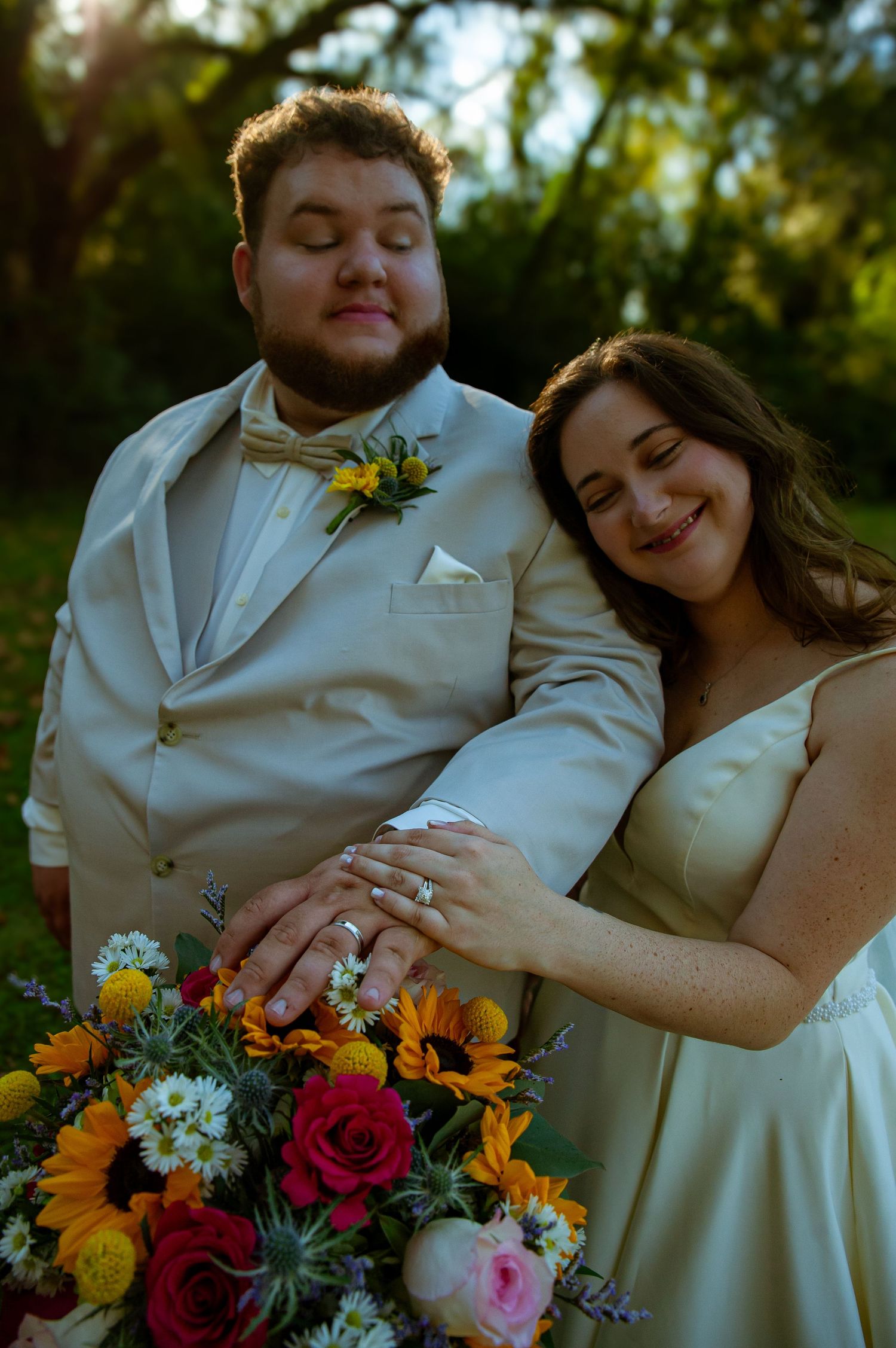 Vibrant wedding bouquet with sunflowers and roses against white dress.