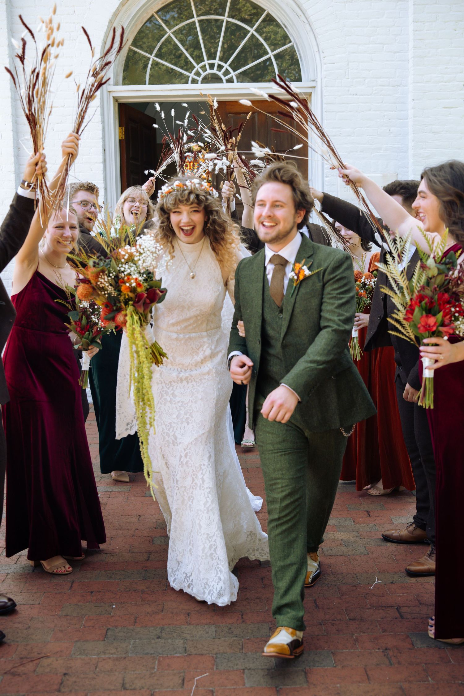 A wedding celebration outside a white church building with guests cheering.