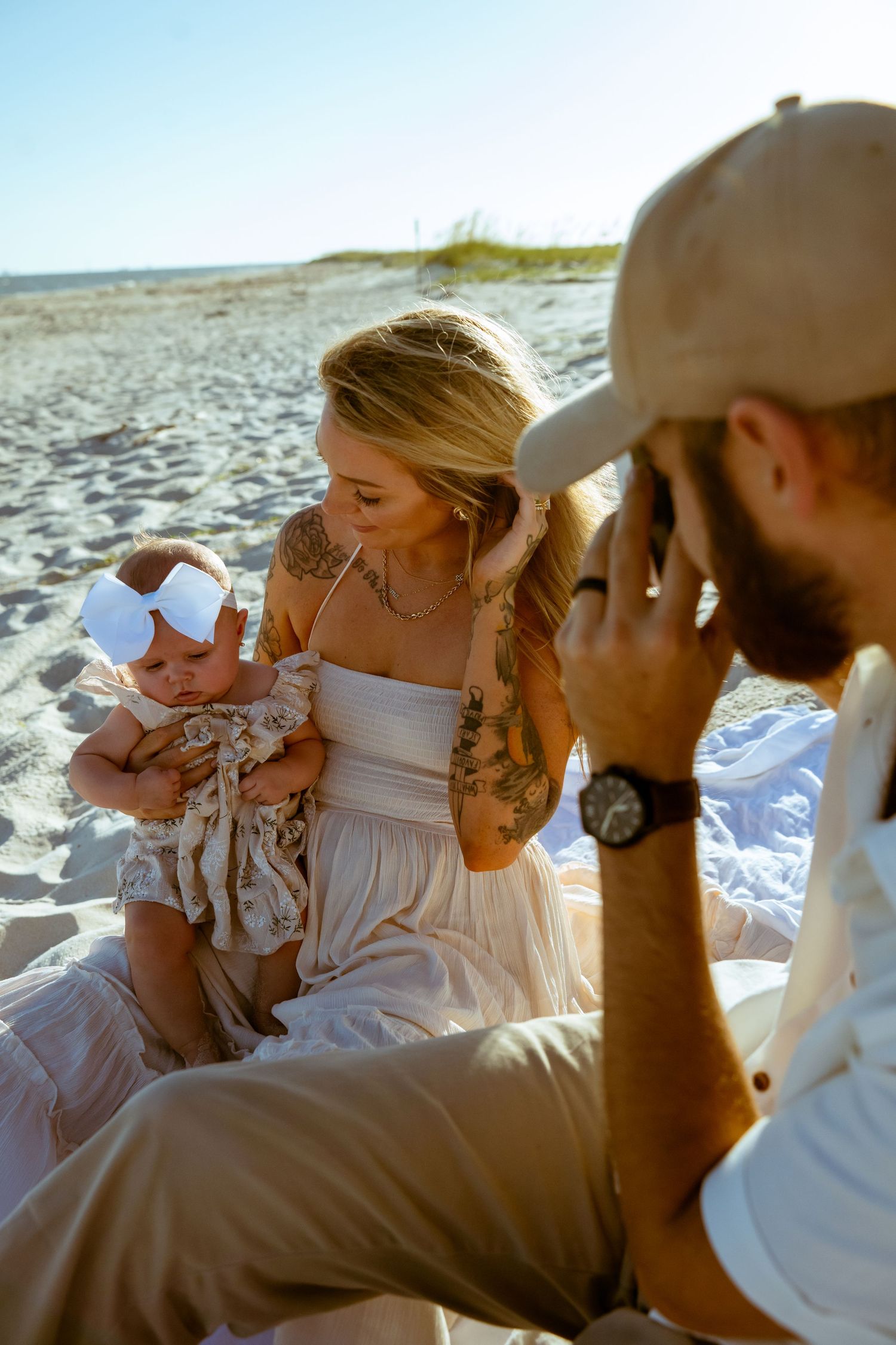 A relaxed family scene on a sandy beach during golden hour.